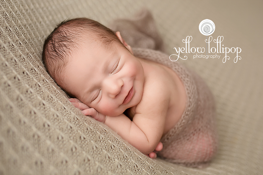 newborn baby boy smiling during newborn photoshoot