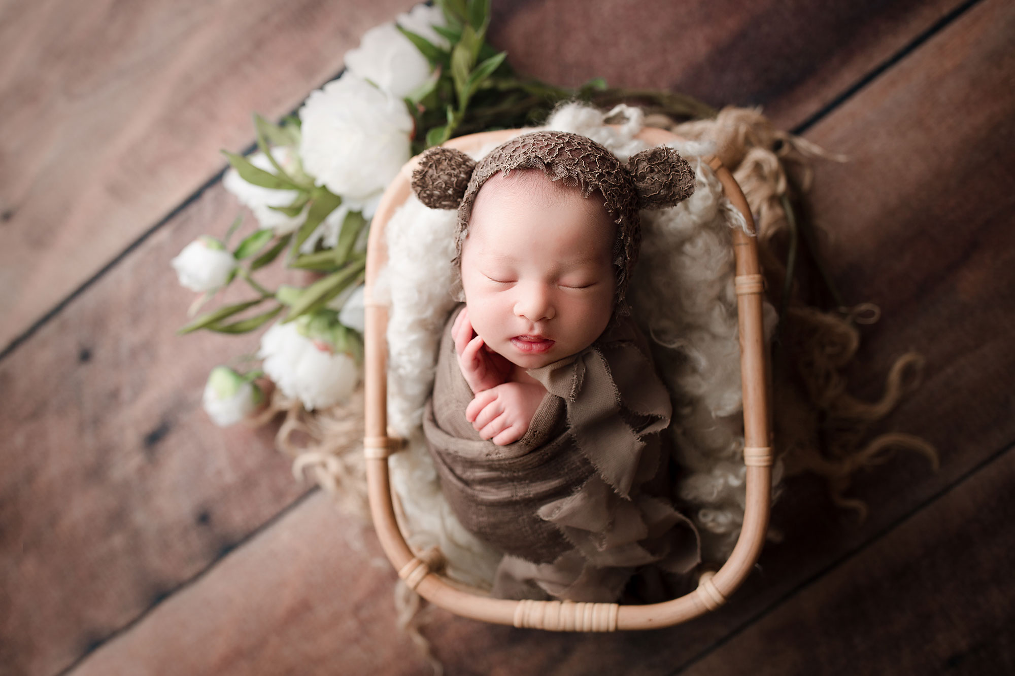 long valley newborn photography baby girl in a bear bonnet sleeping in a basket