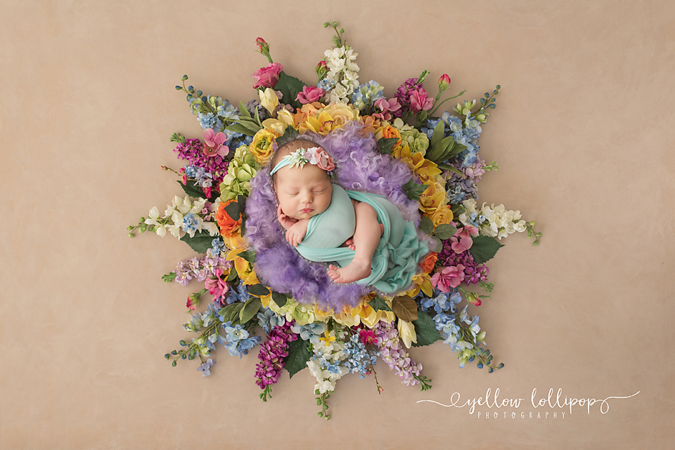 nj newborn photographer creates unique rainbow baby photos of babies sleeping in rainbow colored floral wreath