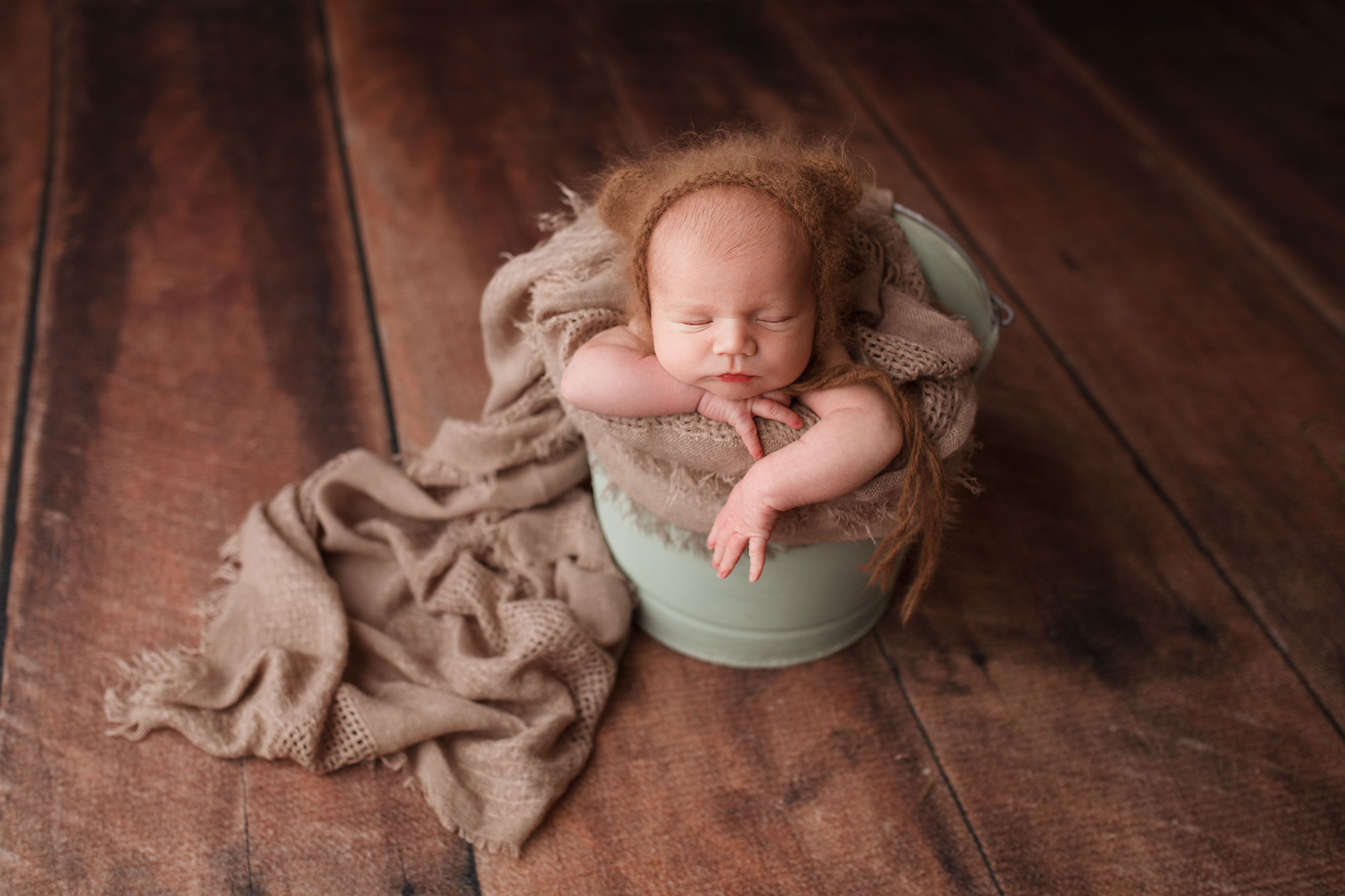 baby wearing bear bonnet in a bucket pose morris county newborn photos
