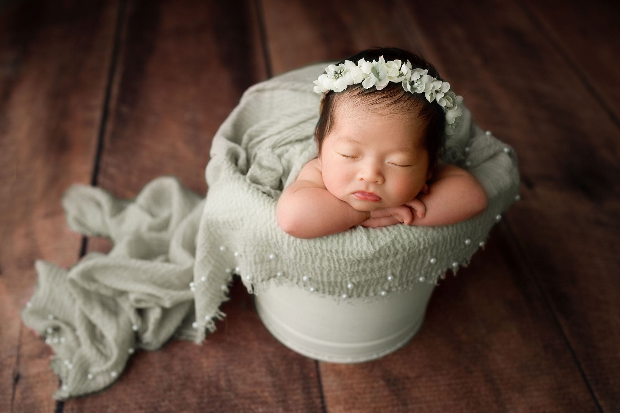 newborn baby girl in a bucket pose