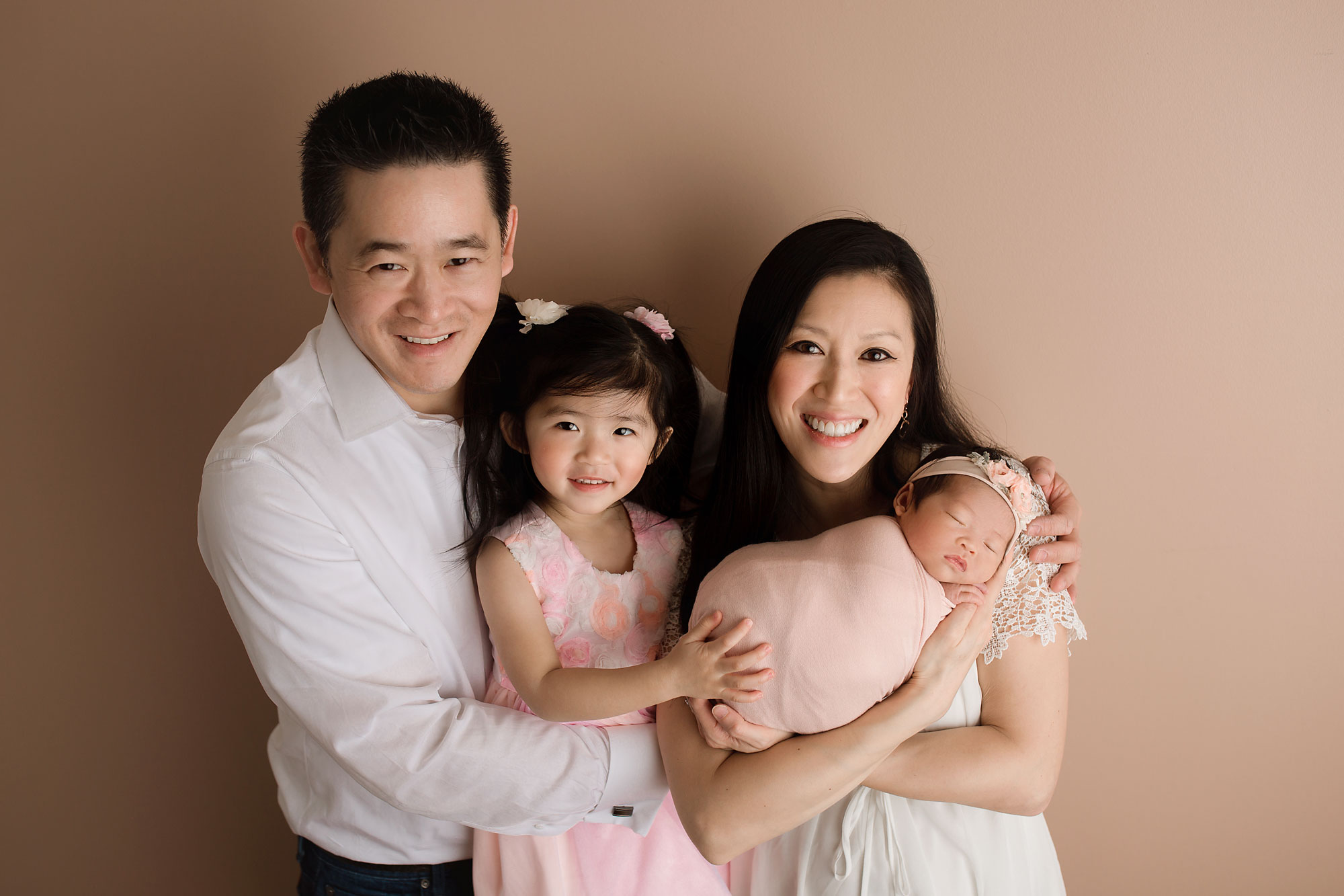 family with newborn and toddler posing