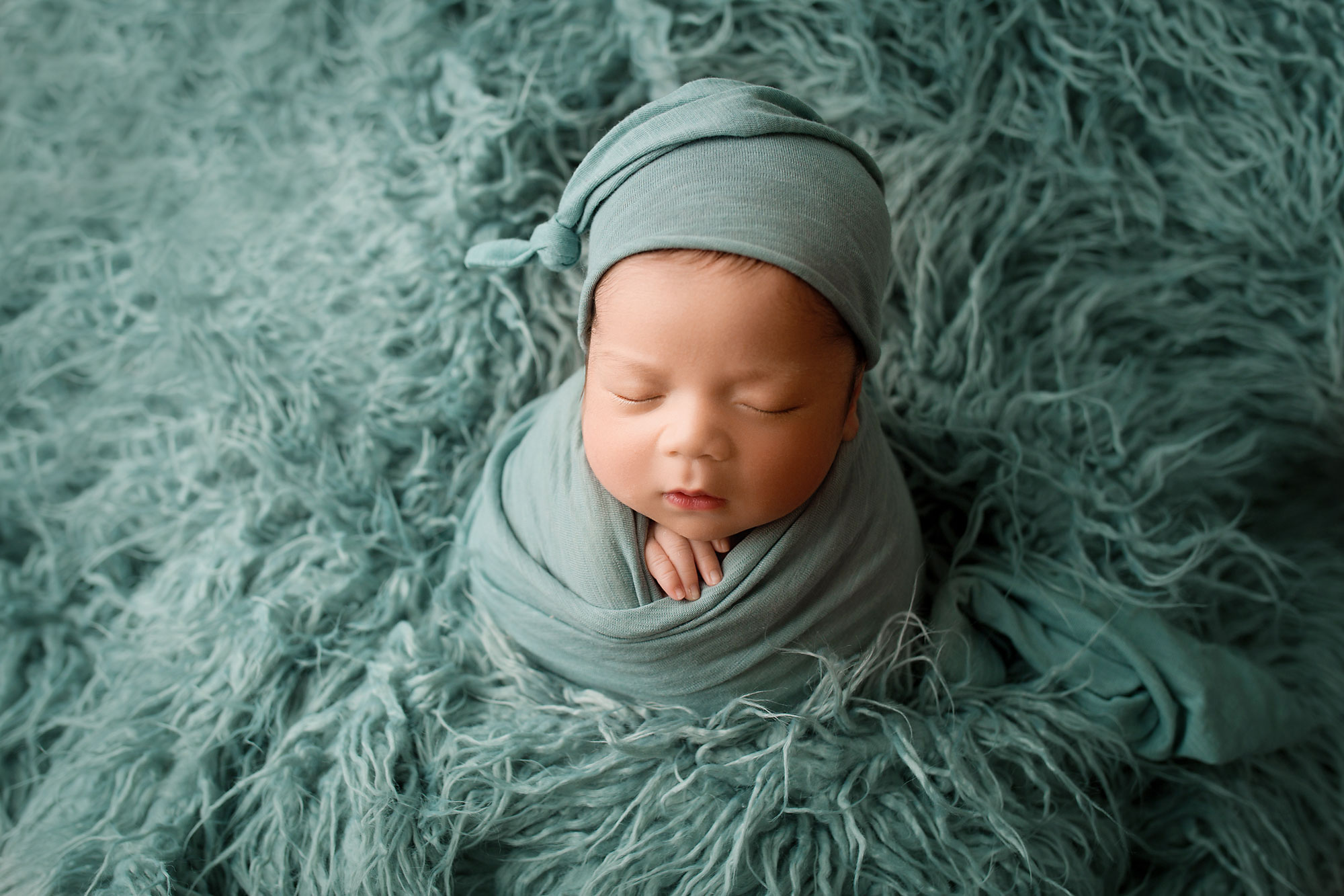 baby boy in blue on a blue flokati potato sack pose newborn posing philadelphia pa 