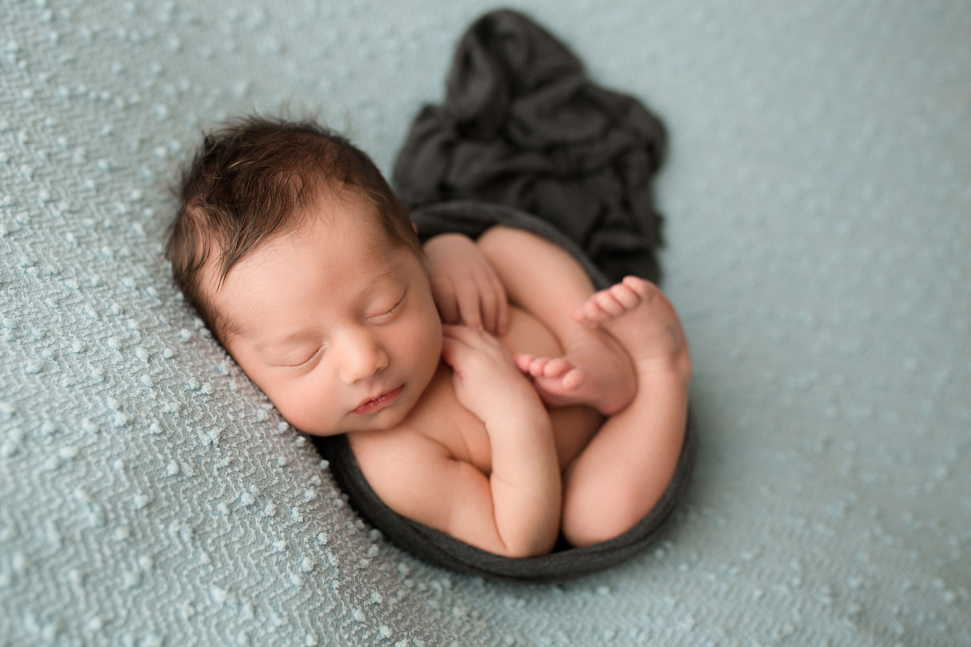 newborn baby boy on a beanbag posing 