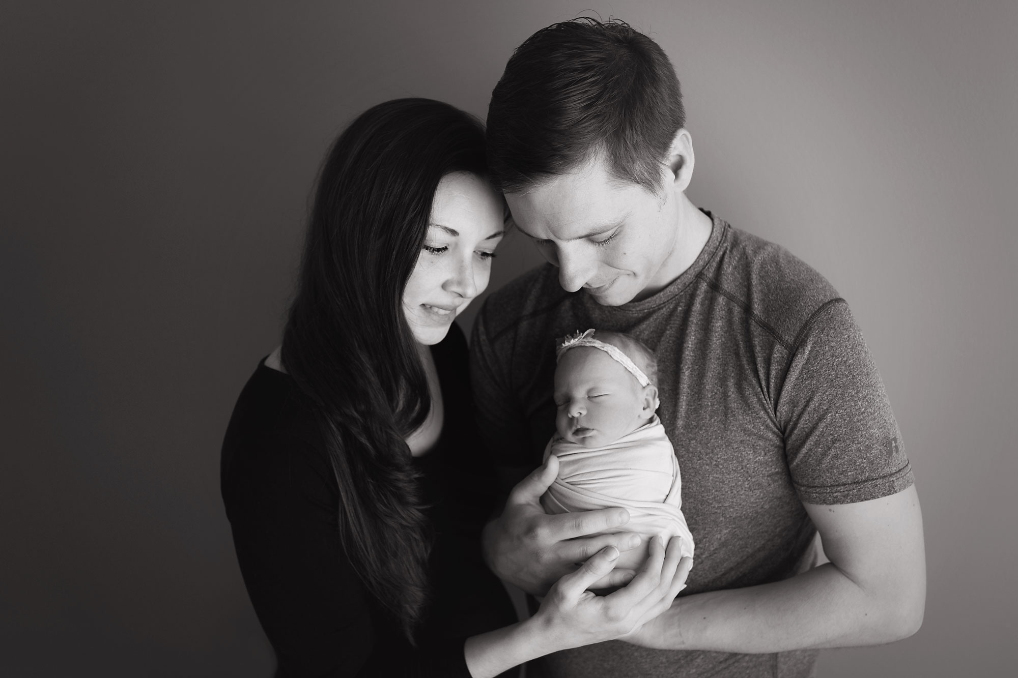parents and baby posing newborn posing with mom and dad black and white photo