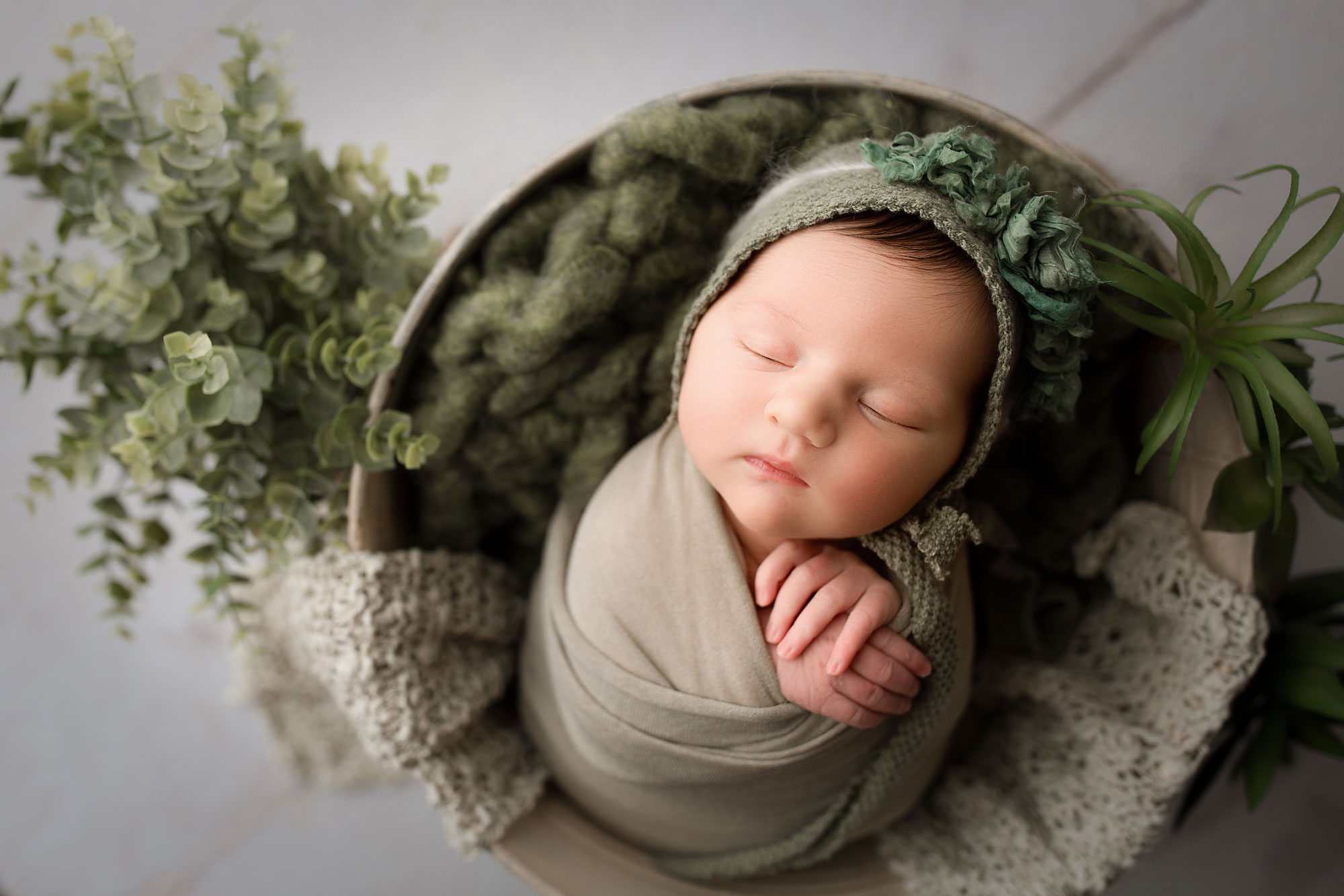 baby girl in green set up in the buckey with greenery easter setup for newborn baby easter eggs baby photo session flemington nj