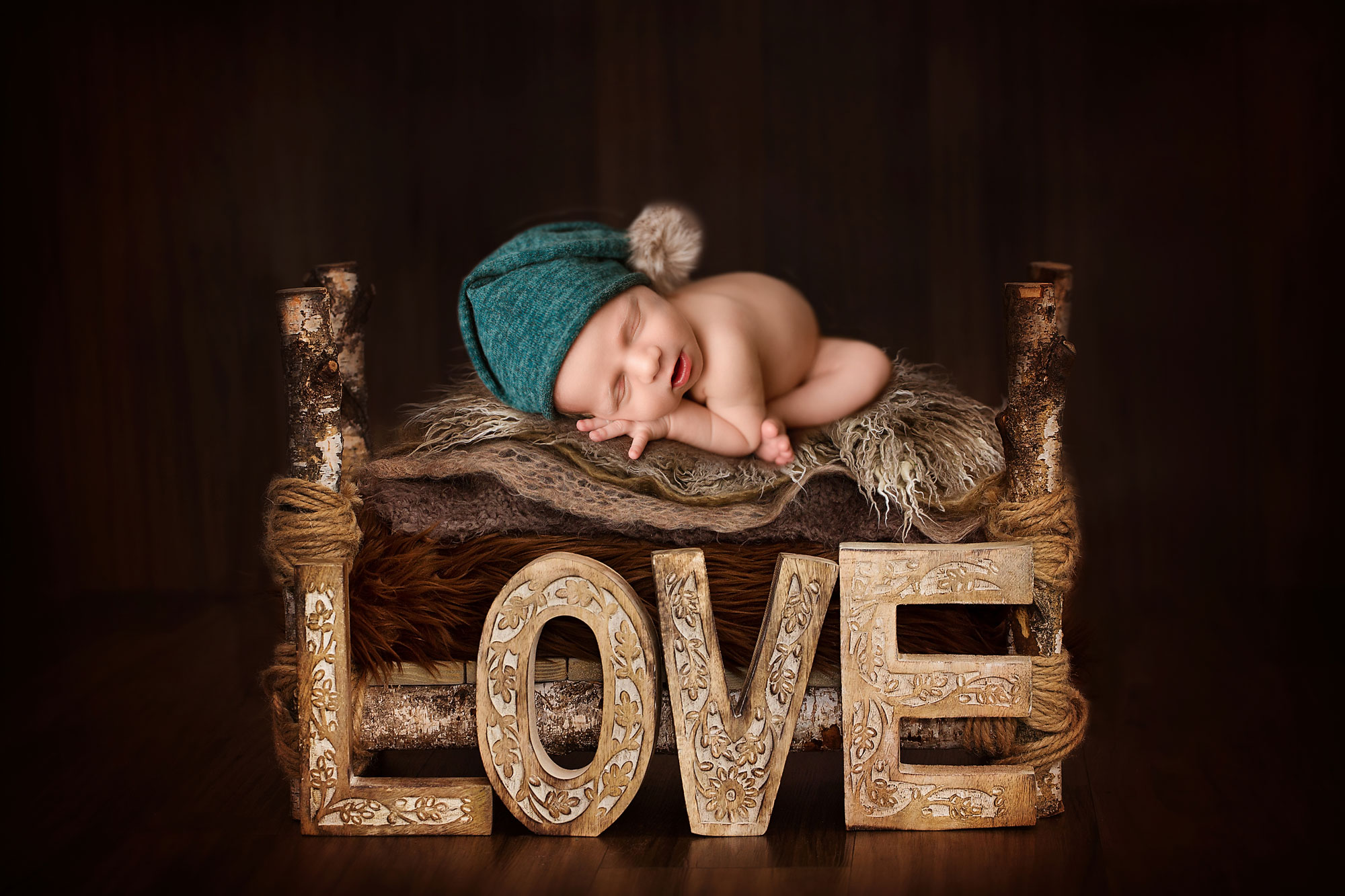 studio newborn photography nj, baby boy asleep on rustic bed with love sign