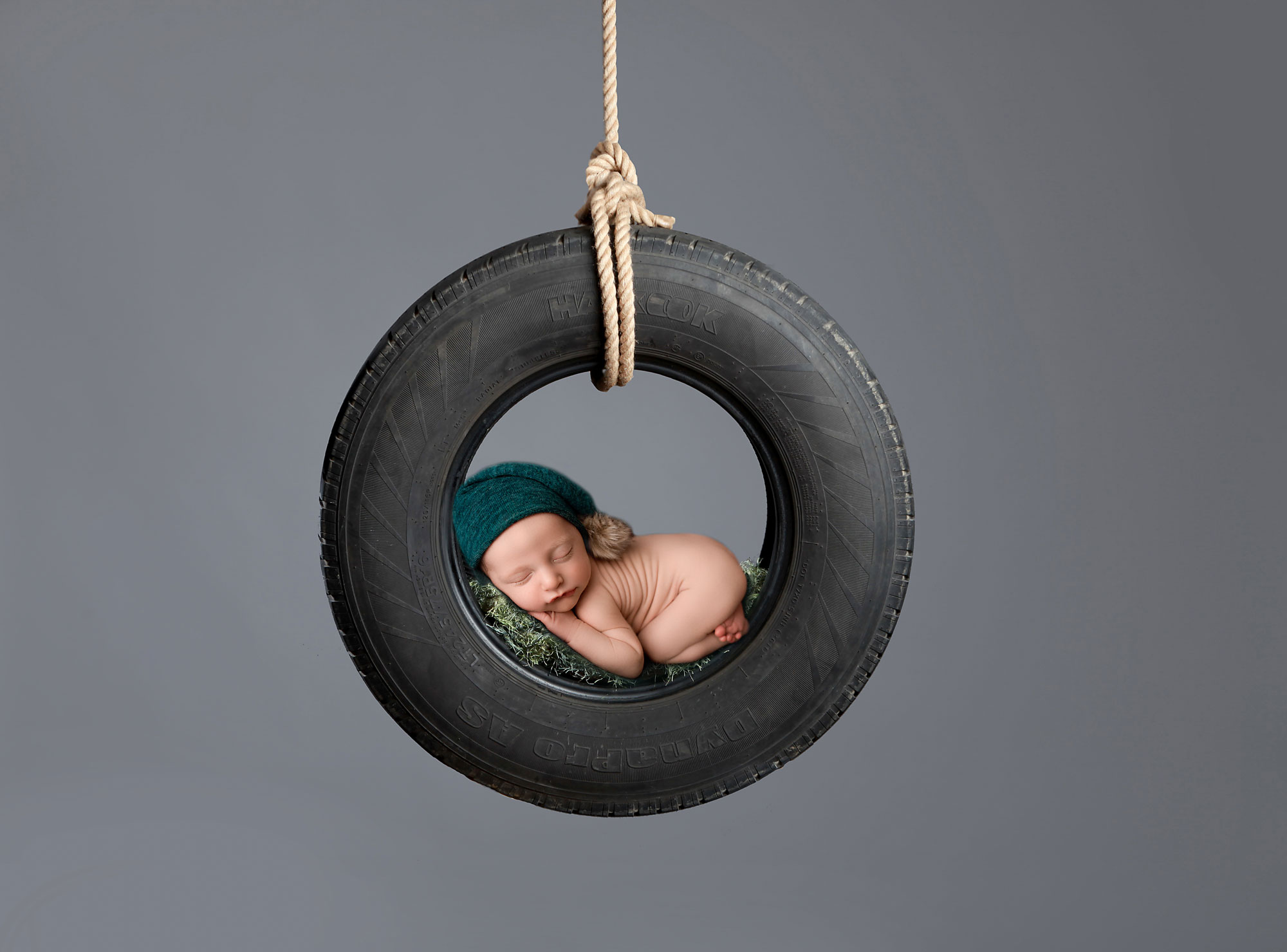 baby boy sleeping on a tire very creative and unique newborn images nj photographer