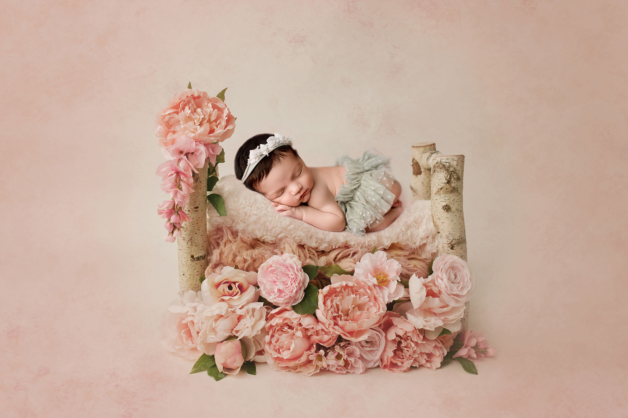 floral bed pink flowers and baby girl in a tutu sleeping on the bed