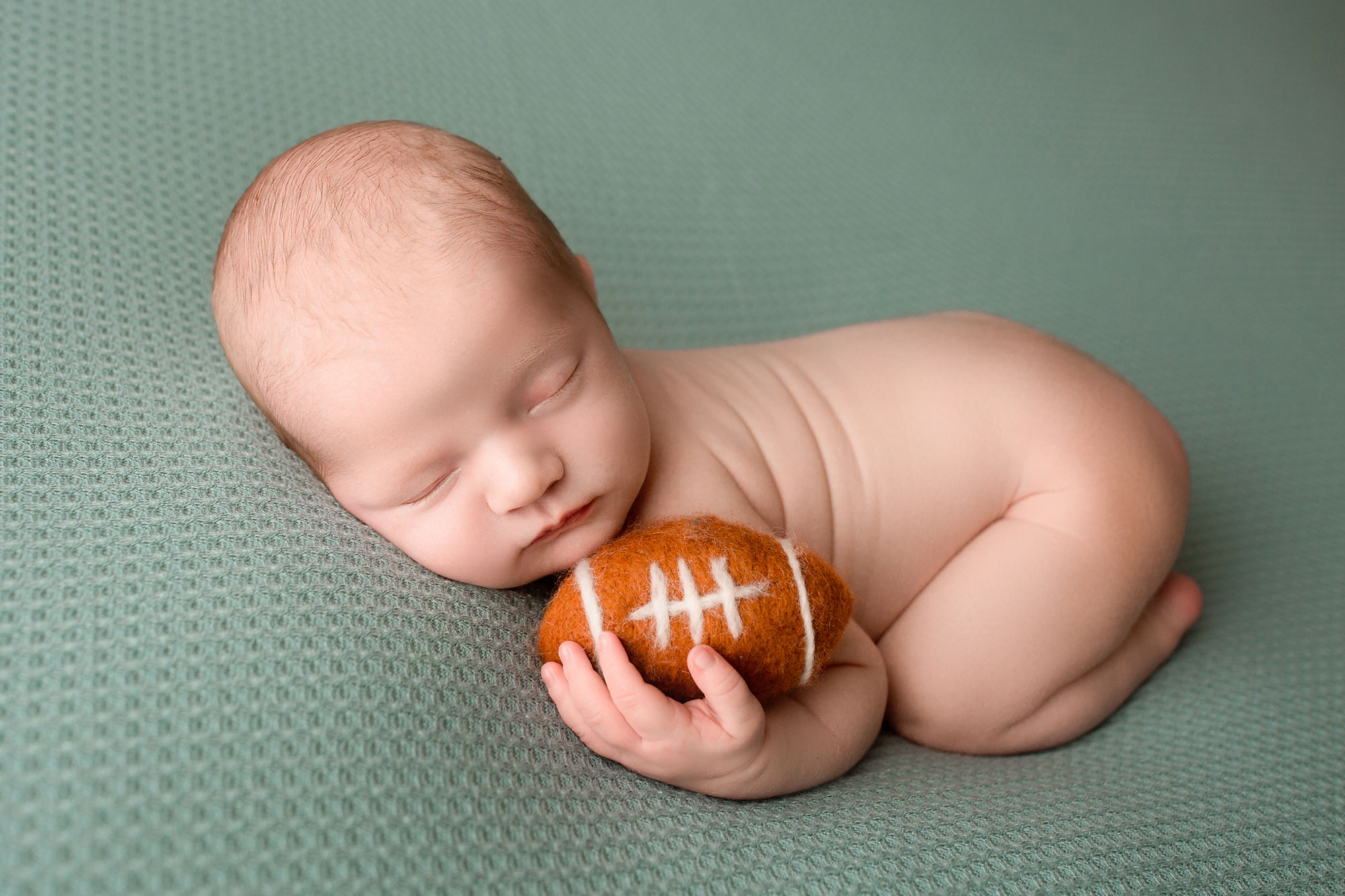 baby boy newborn pictures near me, naked baby boy holding football toy