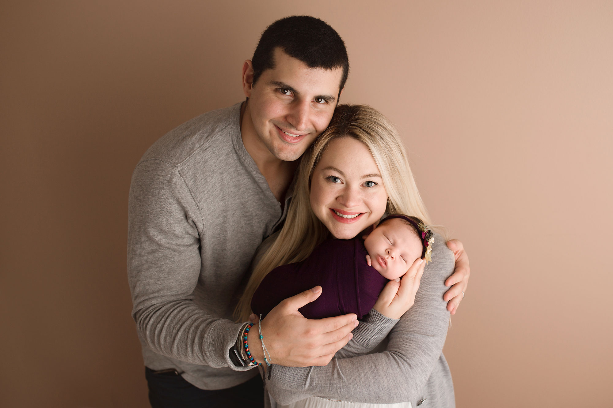 newborn and family photography in new jersey, new parents smiling and holding baby girl