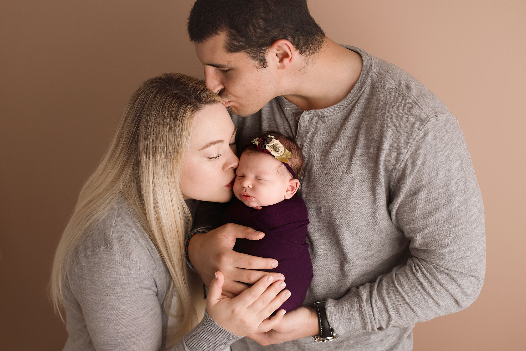 newborn and family photographer new jersey, family portrait with dad kissing mom and mom kissing newborn baby girl