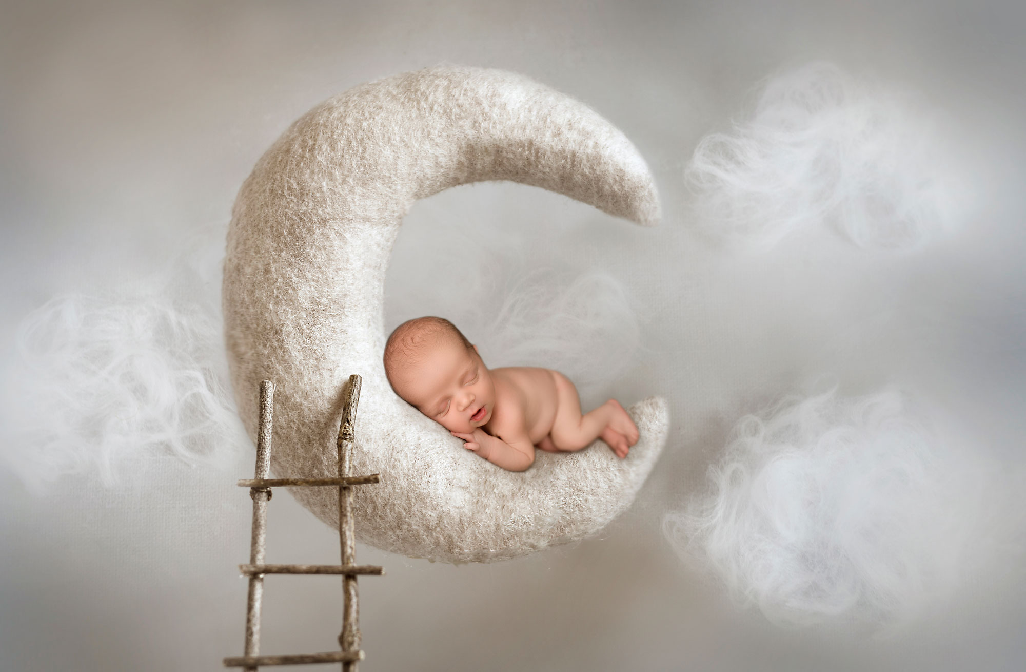 newborn photo session near bergen county nj, baby asleep on moon with wooden ladder and cloudy sky