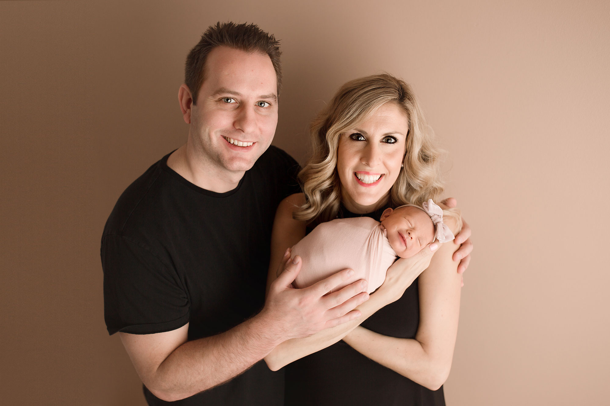 newborn and family photographers in new jersey, parents holding swaddled newborn girl