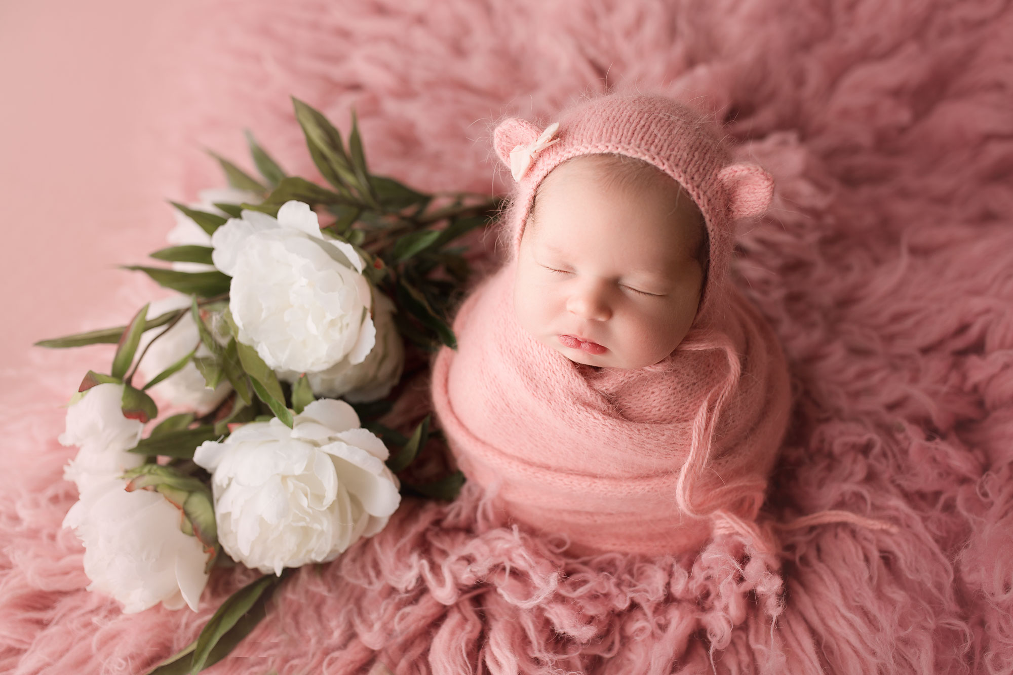 newborn photography new jersey, swaddled baby girl on pink fur with flowers