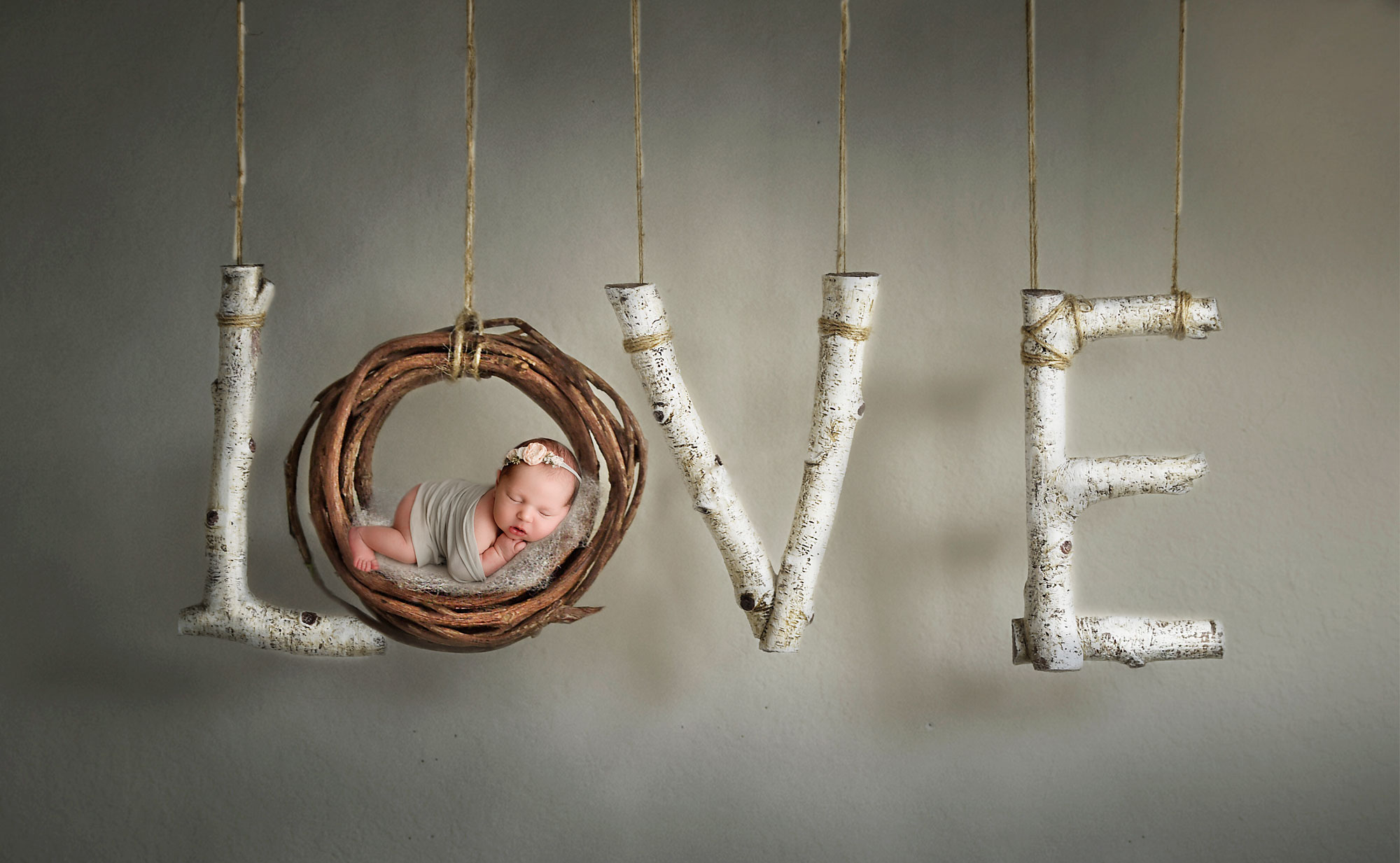 Creative photography of newborn babies baby girl on a love sign digital composite creative newborn photography