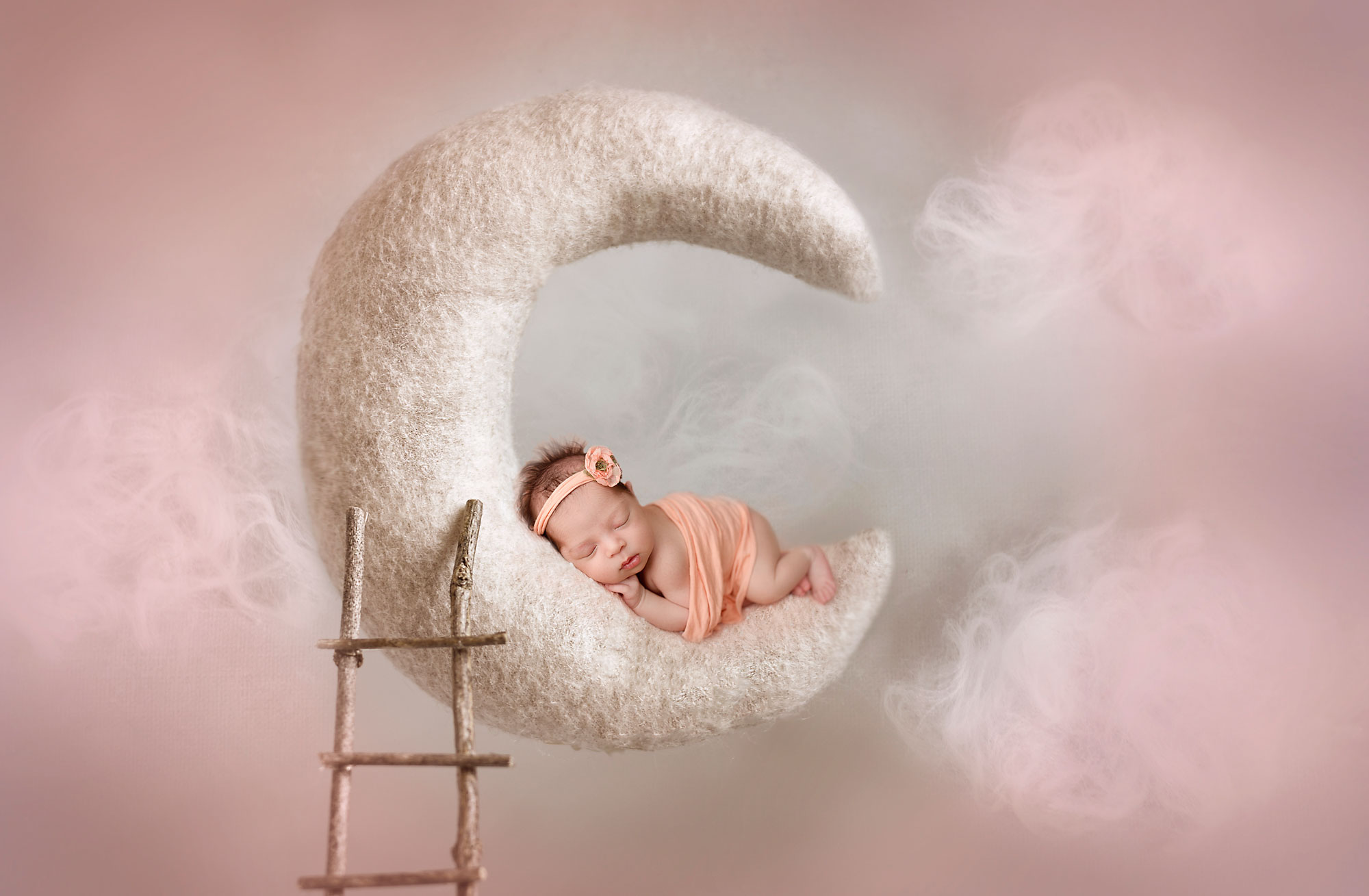 newborn baby girl on a felted moon photo clouds around her baby sleeping 