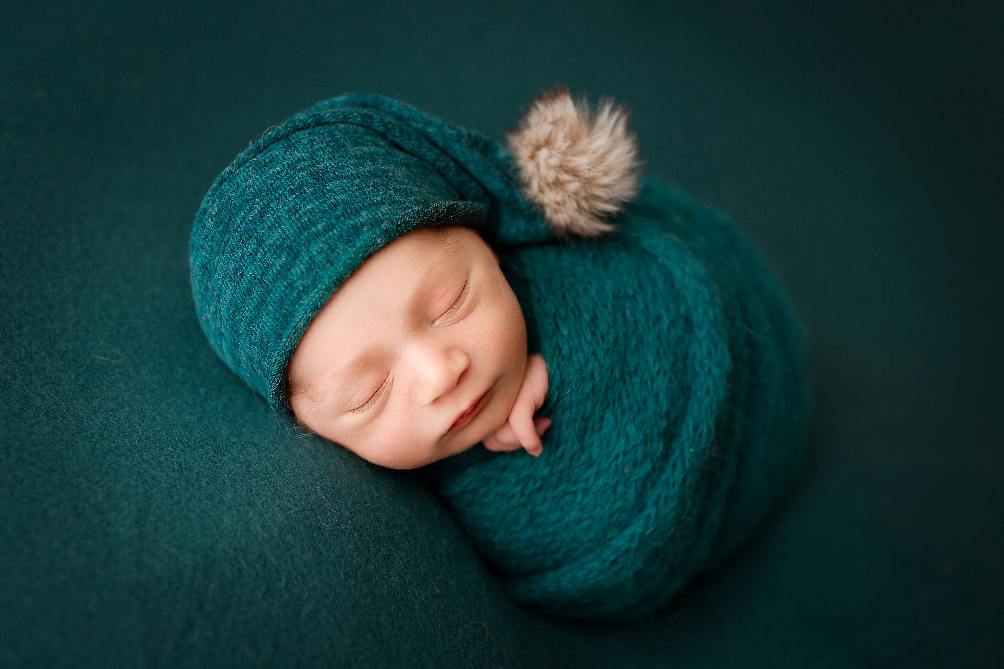 beautiful baby photos new jersey, swaddled baby boy with deep blue-green hat and backdrop