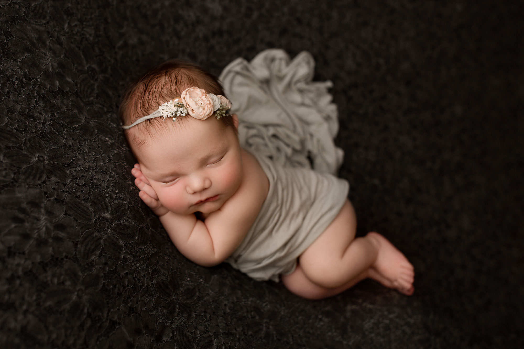 beautiful baby pictures near me, sleeping baby girl in gray wrap and blush pink headband against deep gray backdrop