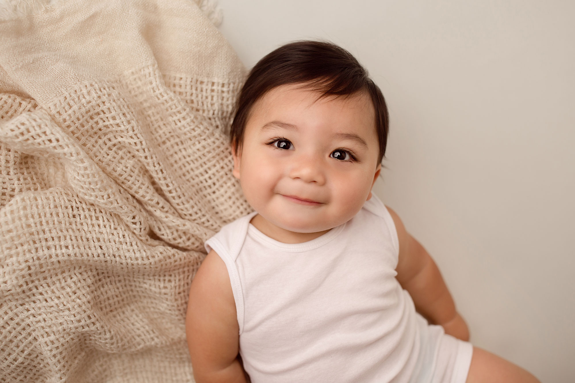 cute baby pictures near me, smiling baby boy in white onesie with rustic throw