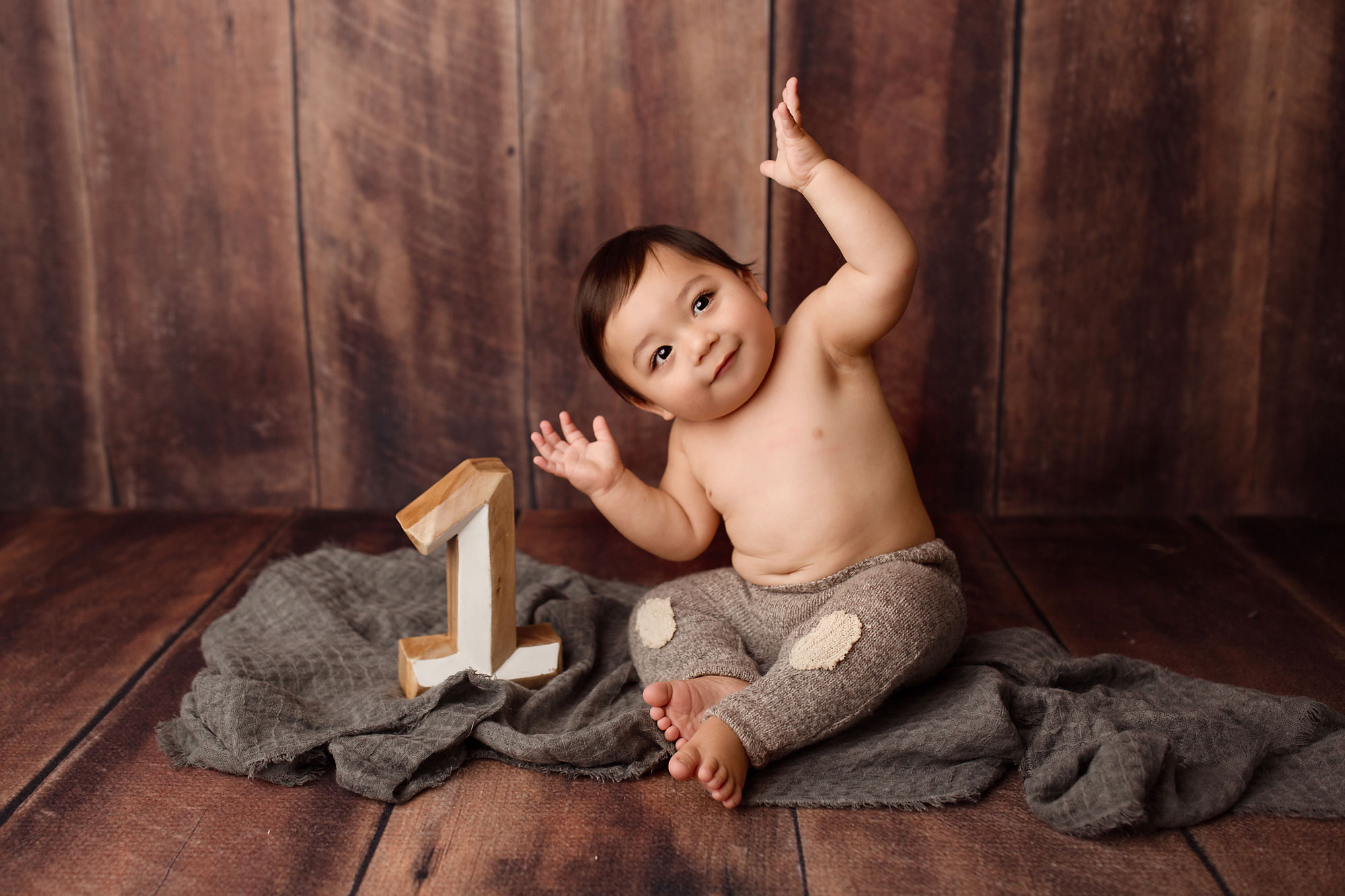 baby birthday photos, toddler boy on gray blanket with wooden number one
