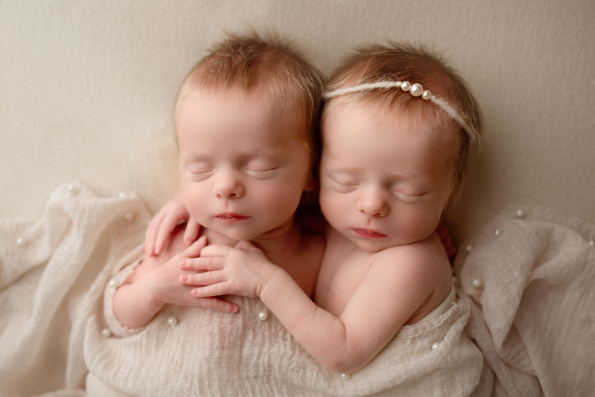 twin rainbow babies photo session, twin girls snuggling in white pearl beaded wrap
