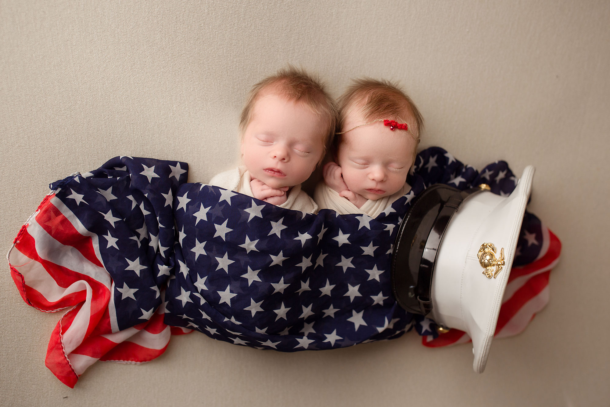 twin girl photo shoot, twins wrapped in American flag with dad's marine cap