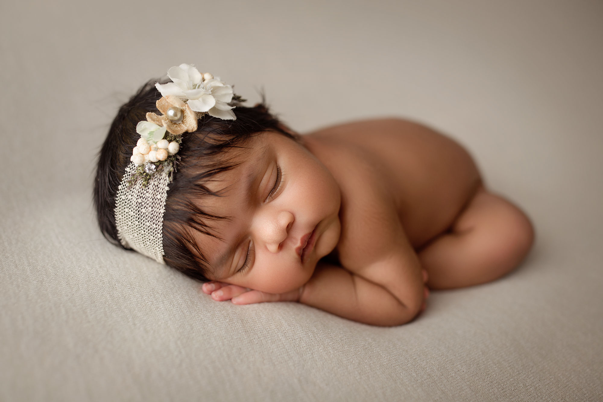 professional newborn photos new jersey, baby girl asleep on white background with pearl and floral headband