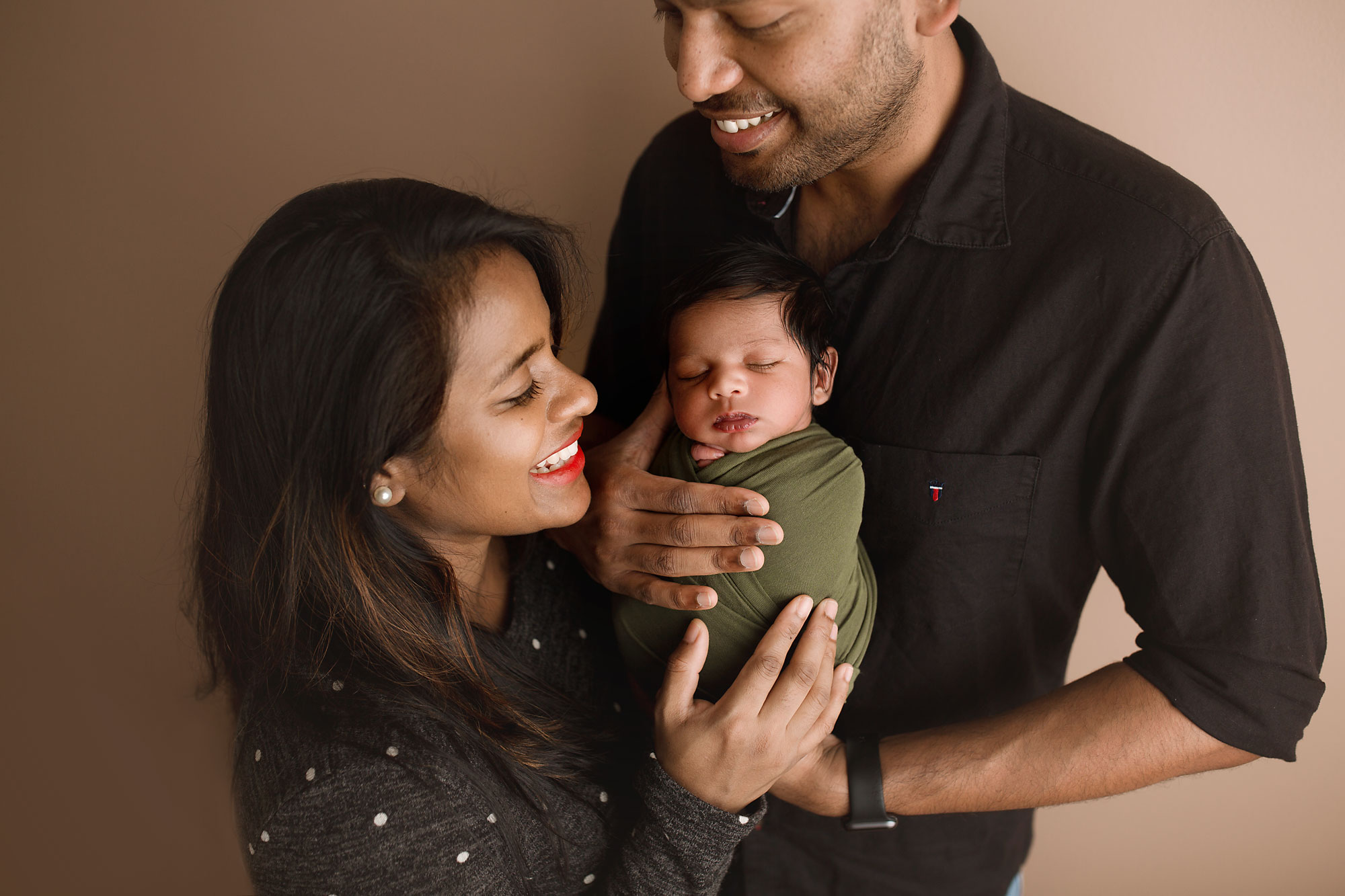 newborn and family pictures lehigh valley, mom and dad holding newborn baby and smiling
