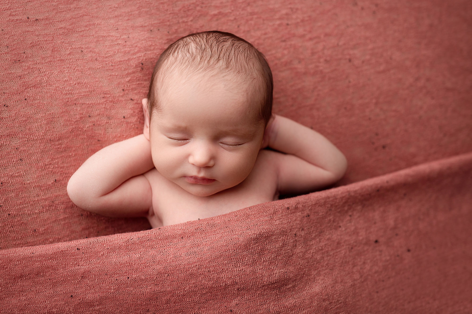jersey city newborn photographer, baby girl sleeping with hands behind head on strawberry pink blanket
