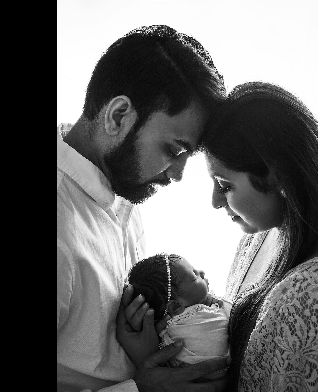 baby and family photography, backlit black and white photo of mother and father holding newborn daughter