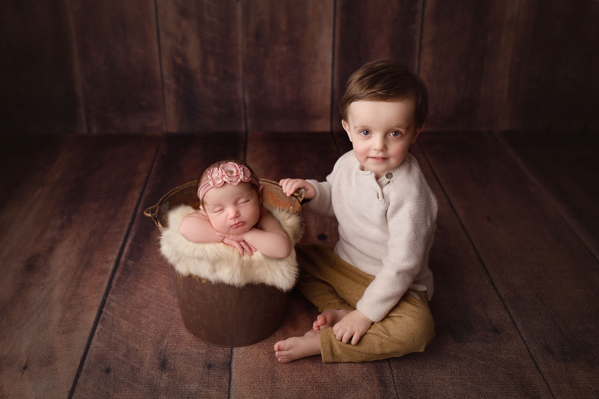 sibling pictures nj, baby girl asleep in bucket with big brother seated beside her