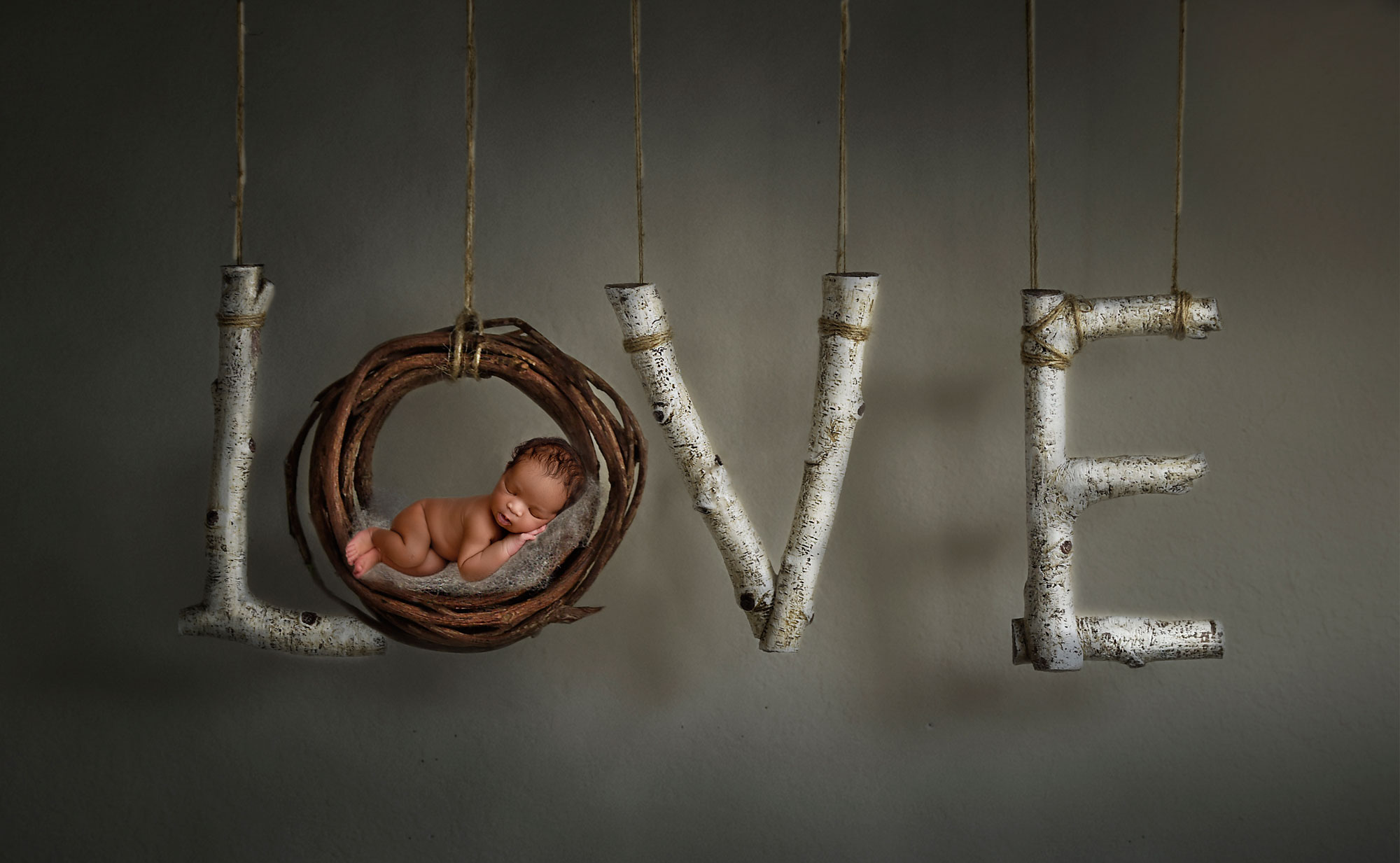 creative newborn photography, baby asleep in O of hanging wooden LOVE sign