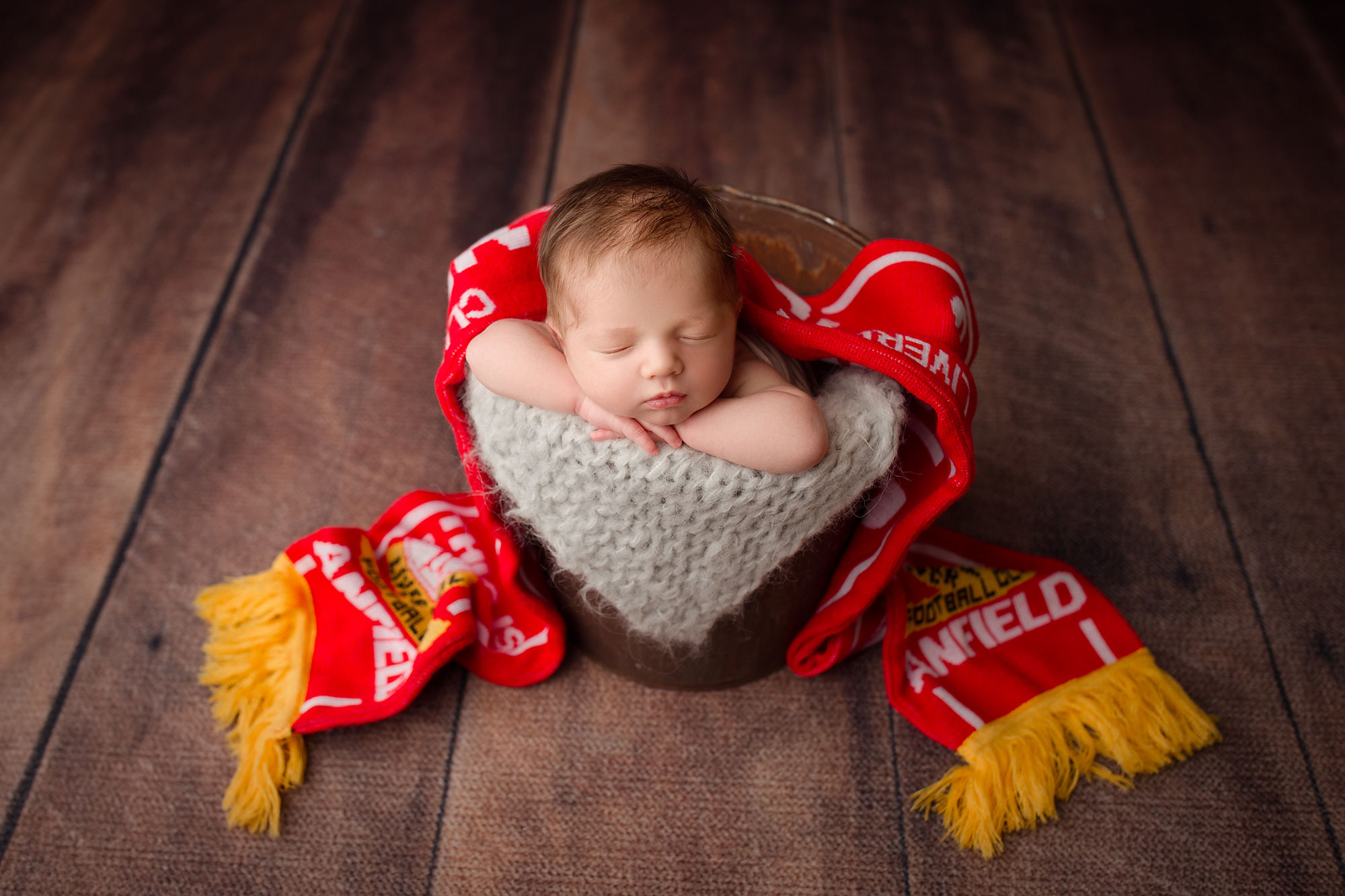 new jersey photographer, baby asleep in wooden bucket with red and yellow sports scarf