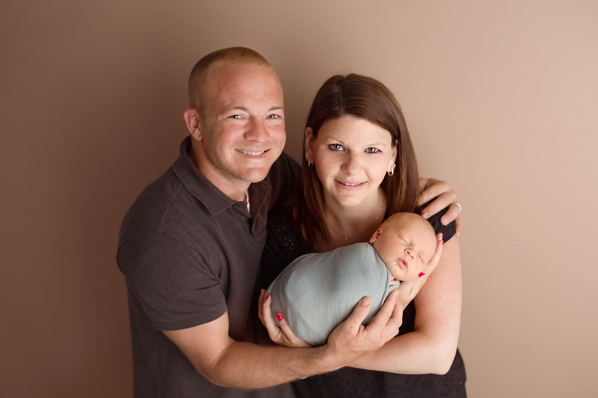 family and newborn photography, mom and dad holding swaddled son