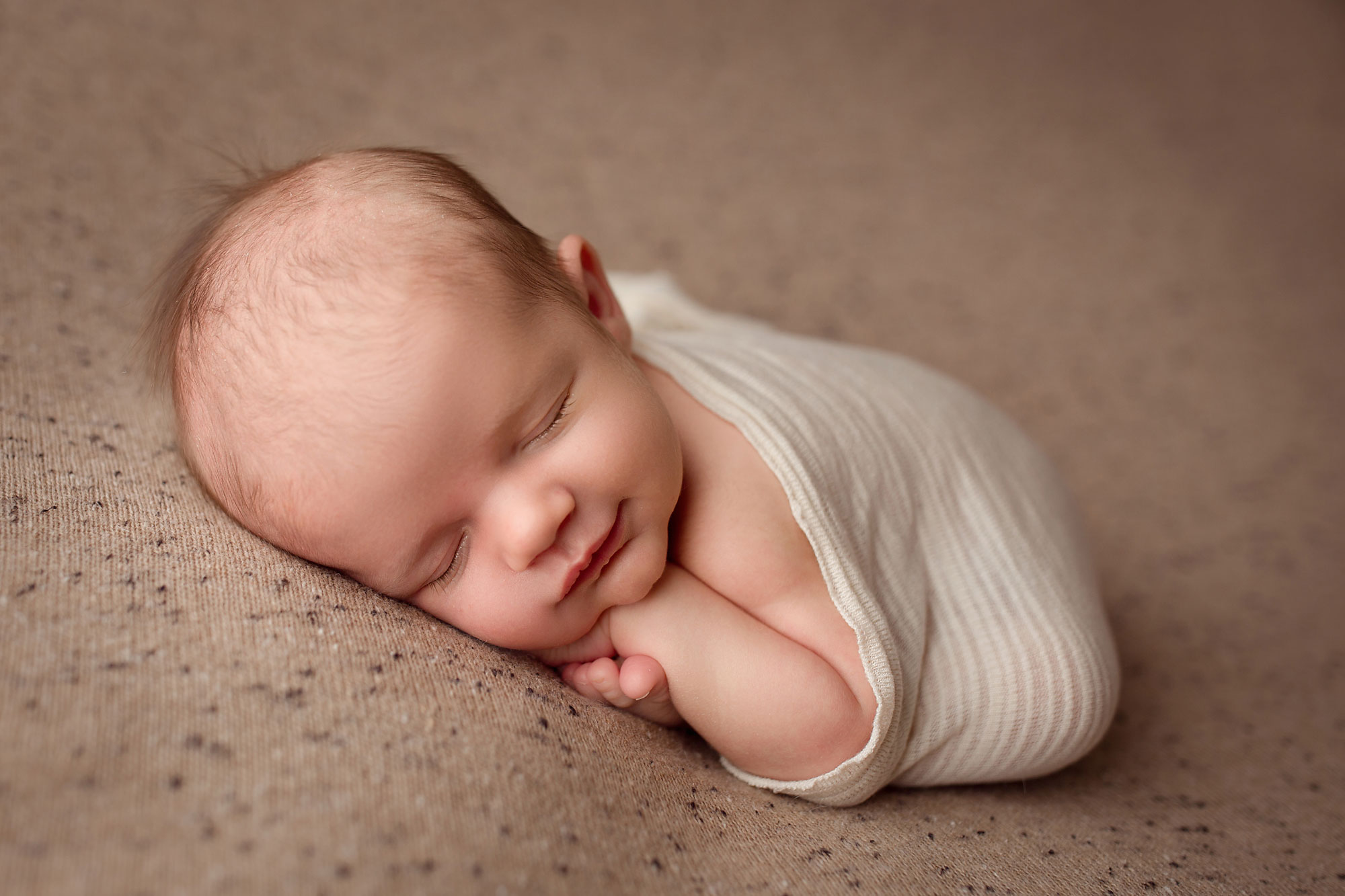 newborn portrait photographer new jersey, baby sleeping on tummy on sand-colored beanbag