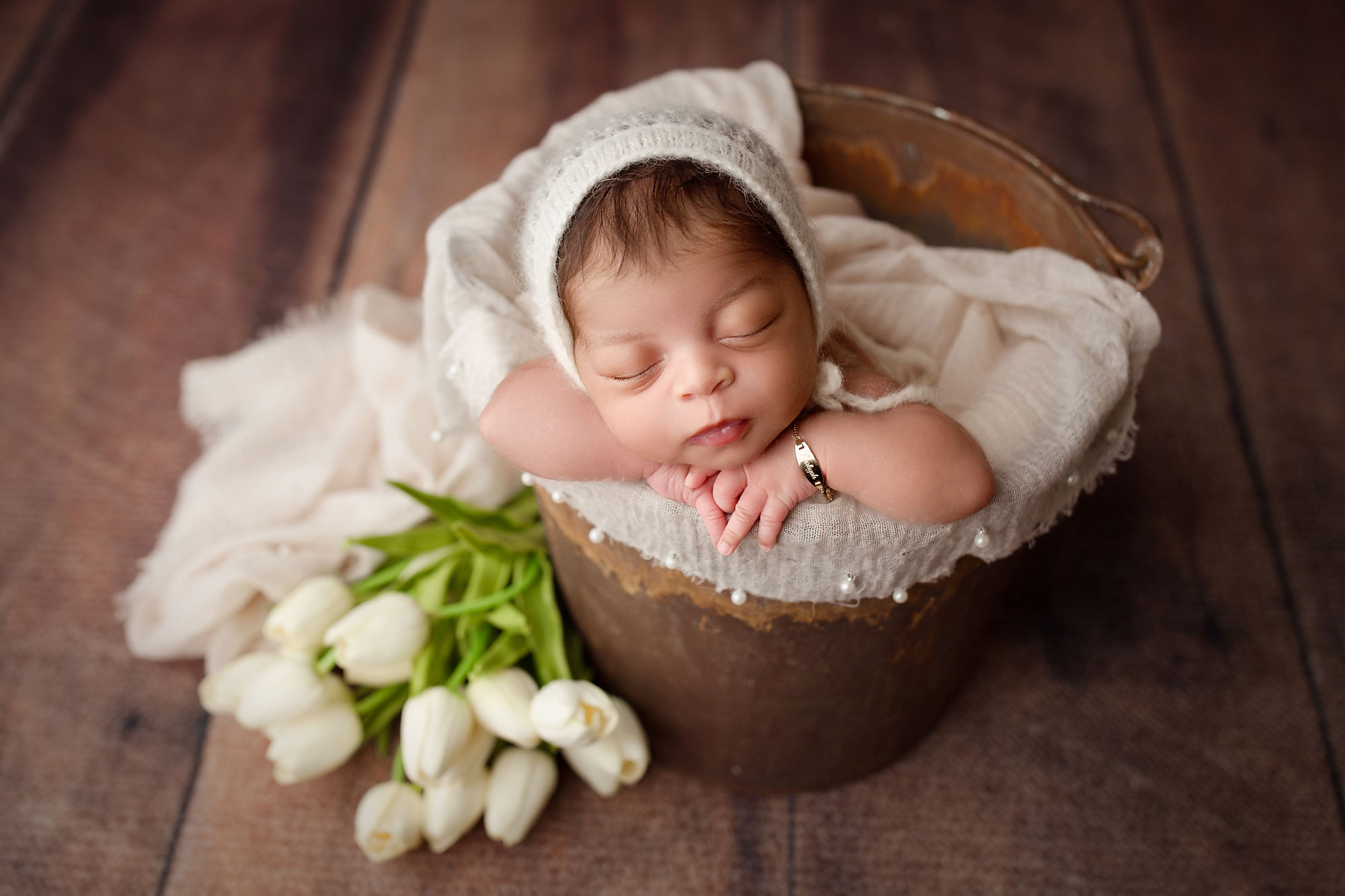 newborn pictures new jersey, baby in white with pearls and tulips against rustic backdrop