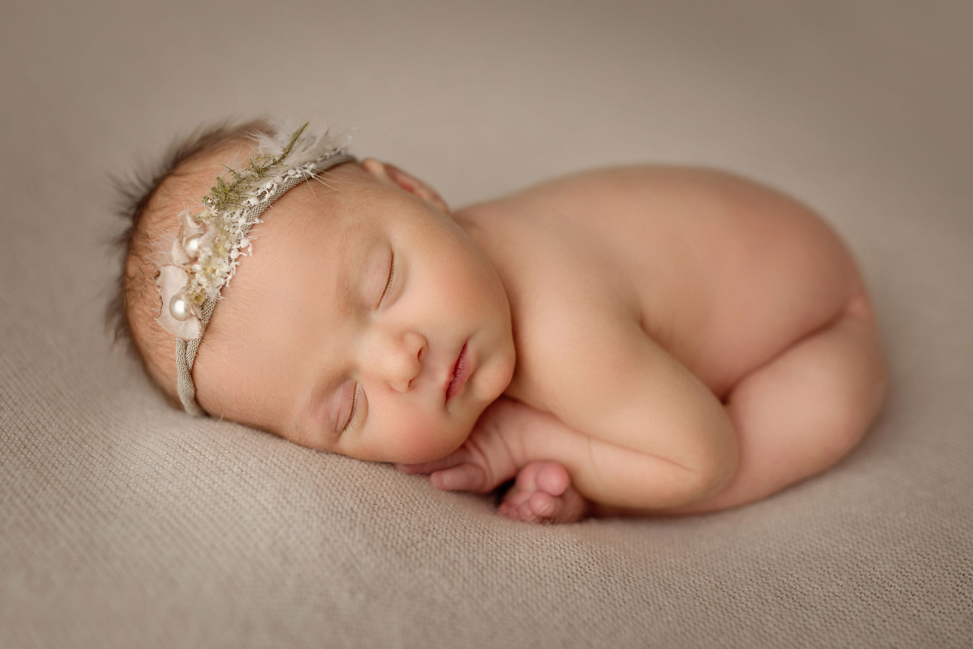 newborn photo session nj, baby girl with pearl and lace headband sleeping on beanbag