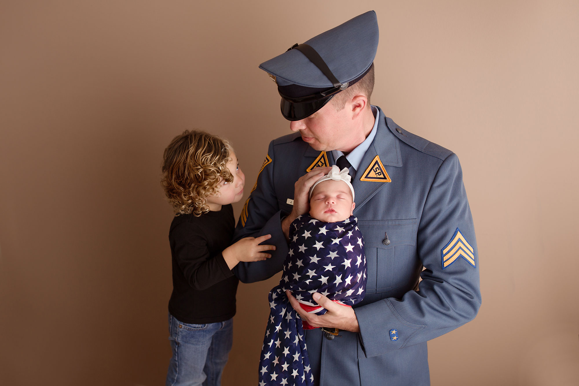newborn and family photography, baby wrapped in flag being held by dad in uniform