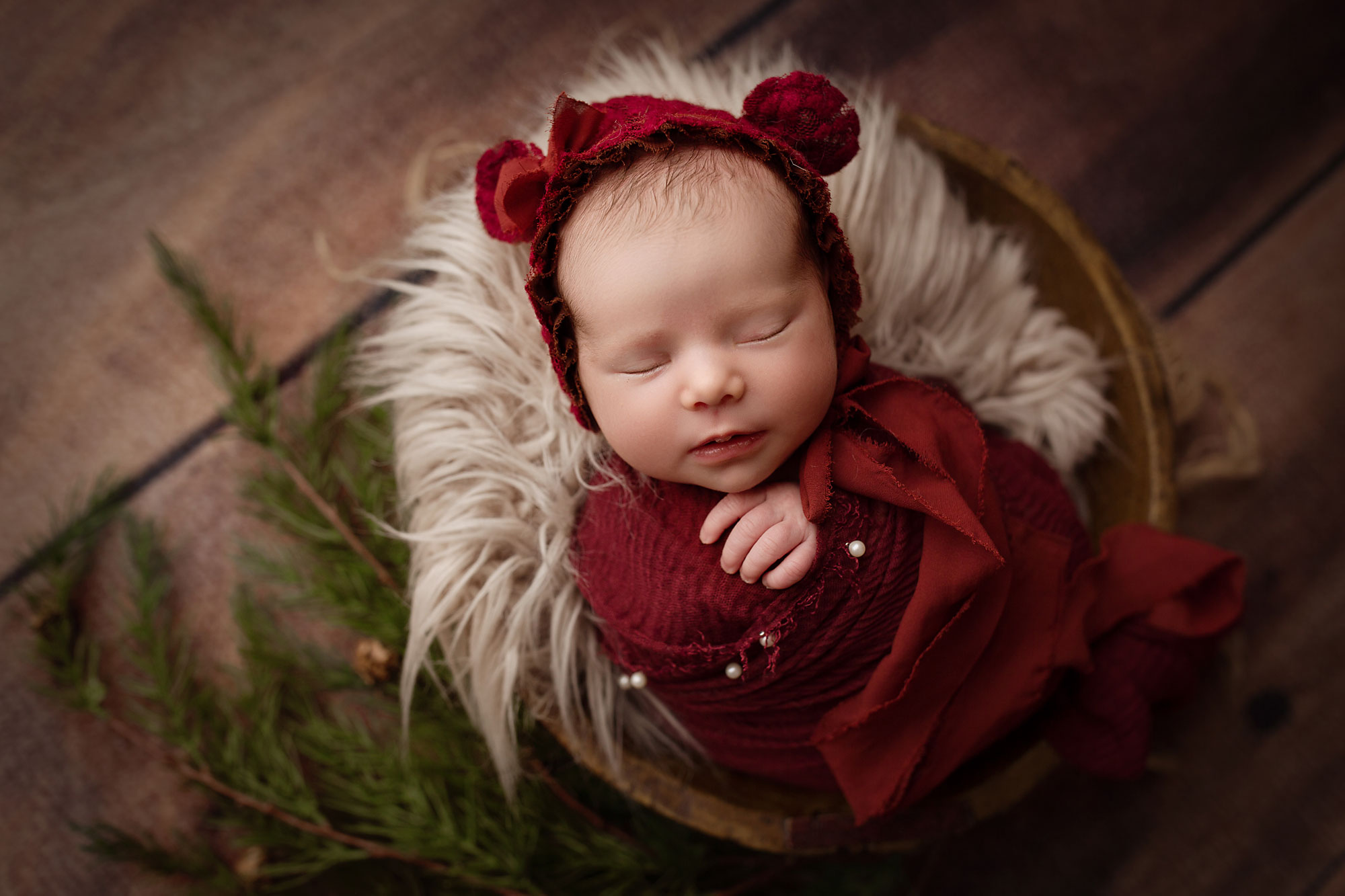 baby girl swaddled in red sleeping in bucket, newborn christmas pictures nj