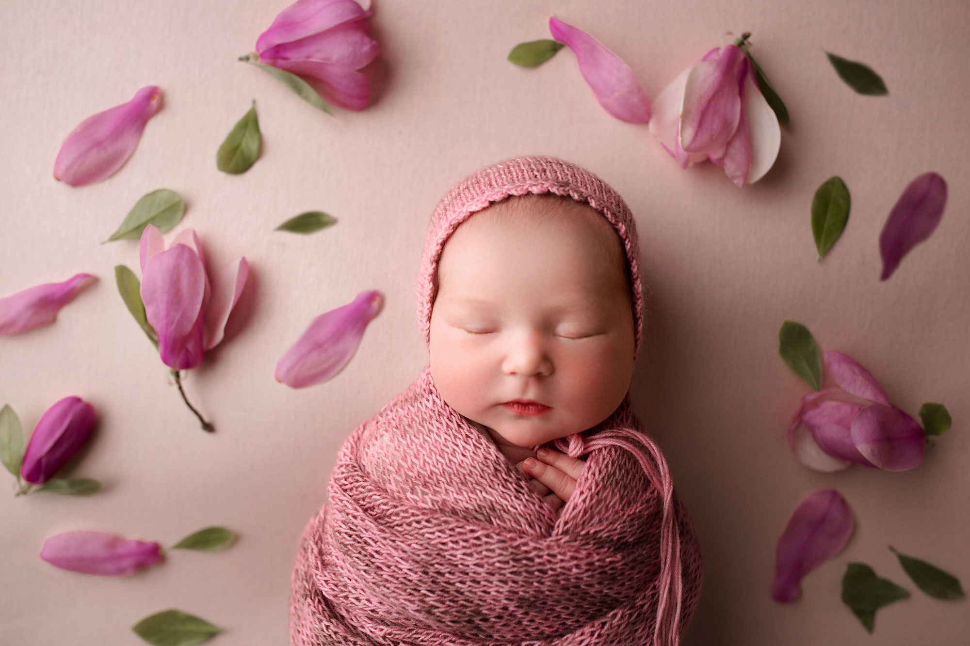 baby girl sleeping surrounded by magnolias 