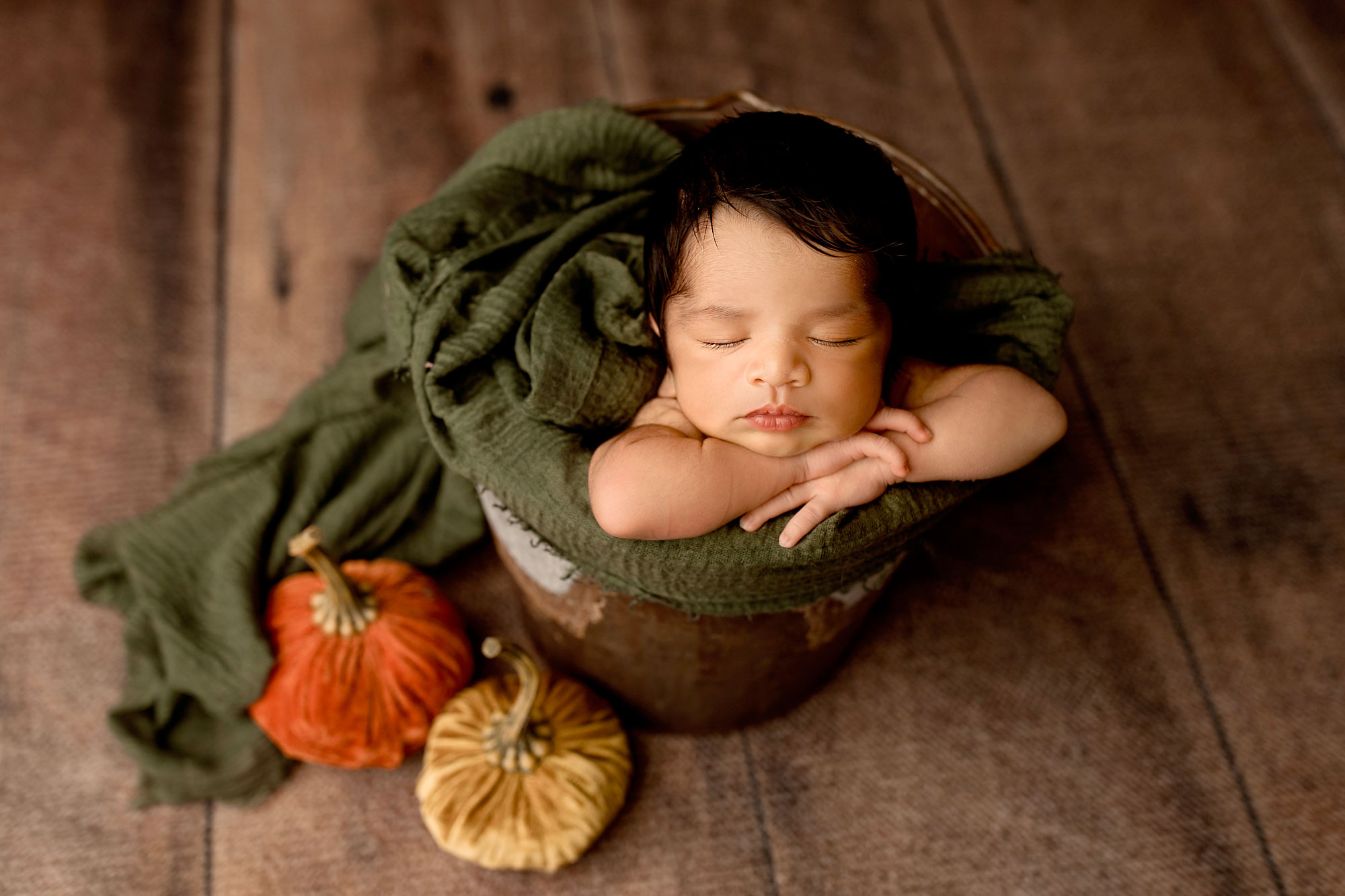 boy sleeping in a bucket with pumpkins