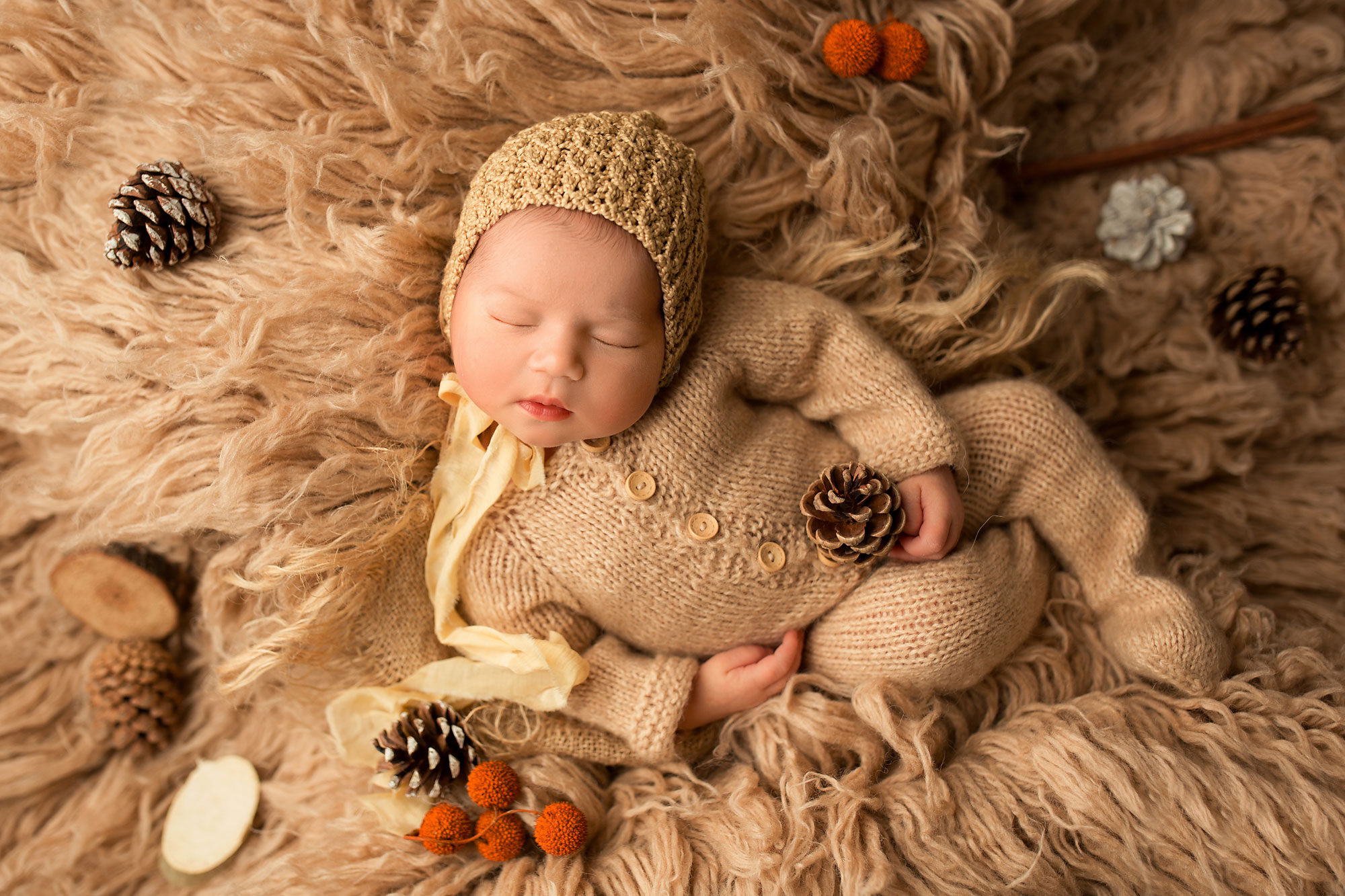 newborn baby girl in a beige christmas set up
