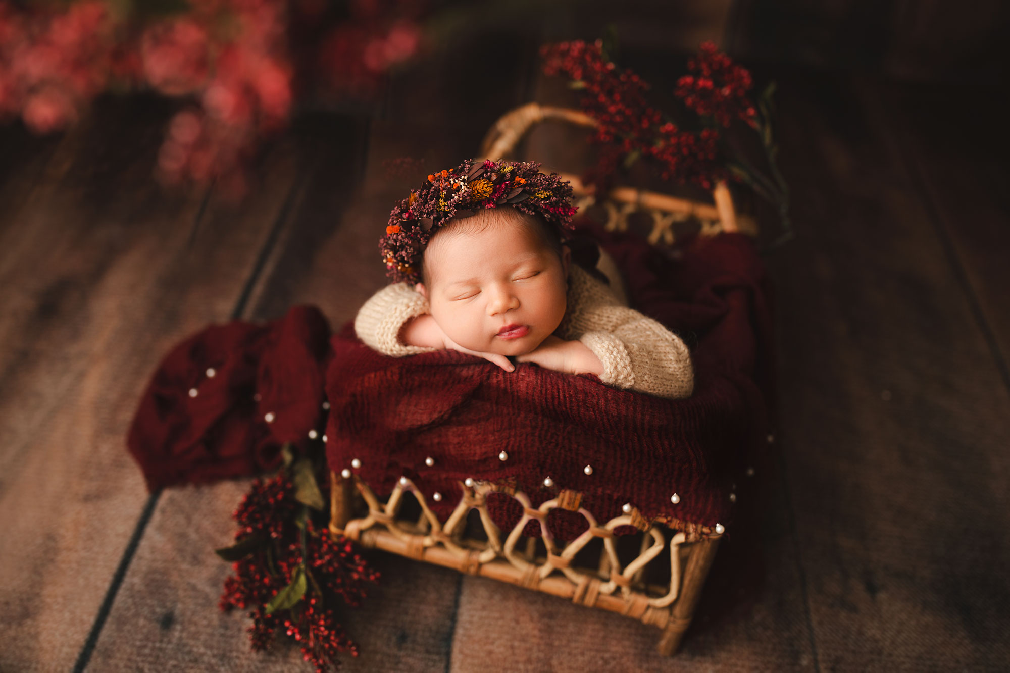 baby girl in a bed with red flowers