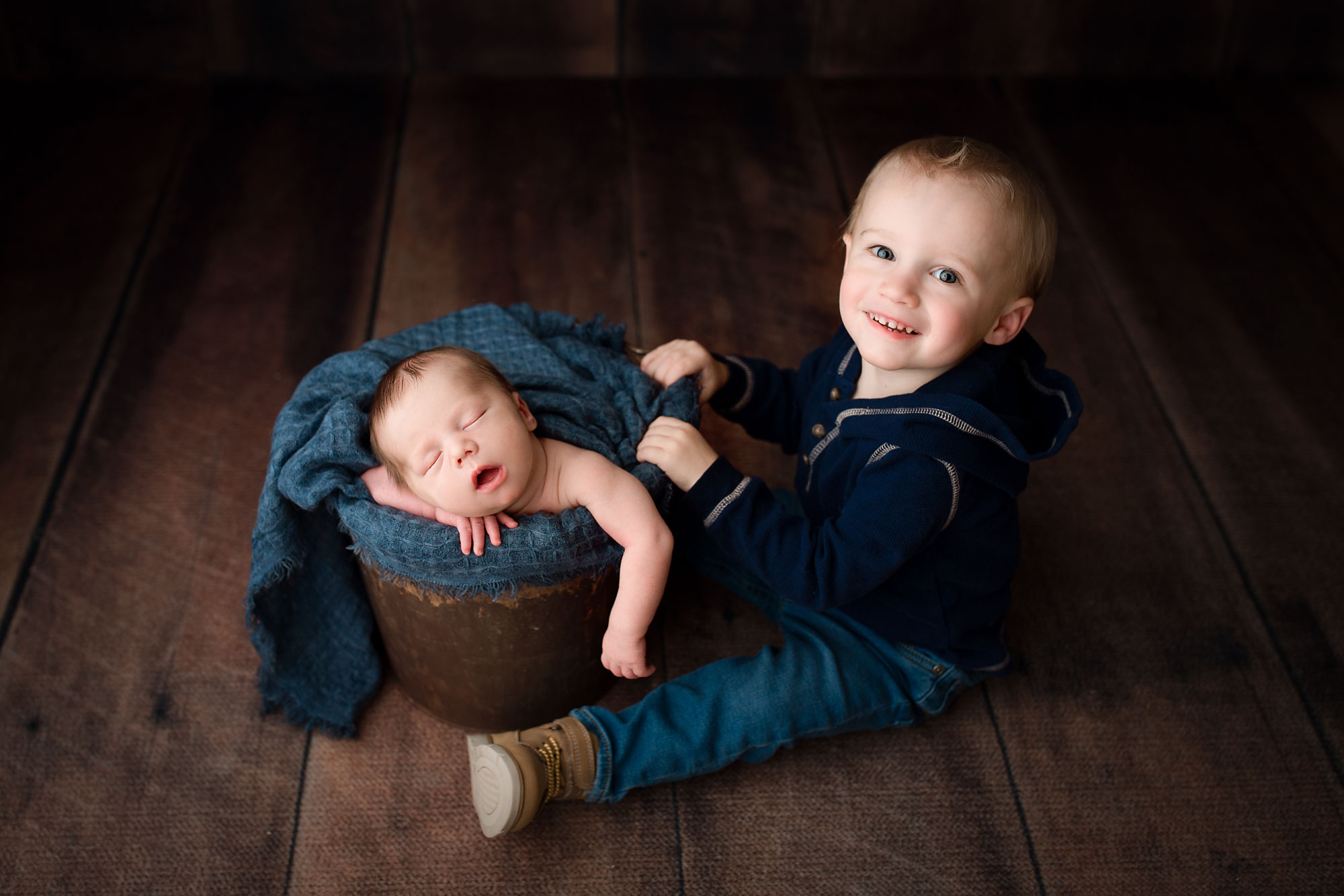 baby boy sleeping in a bucket with older brother next to him NJ newborn photography 