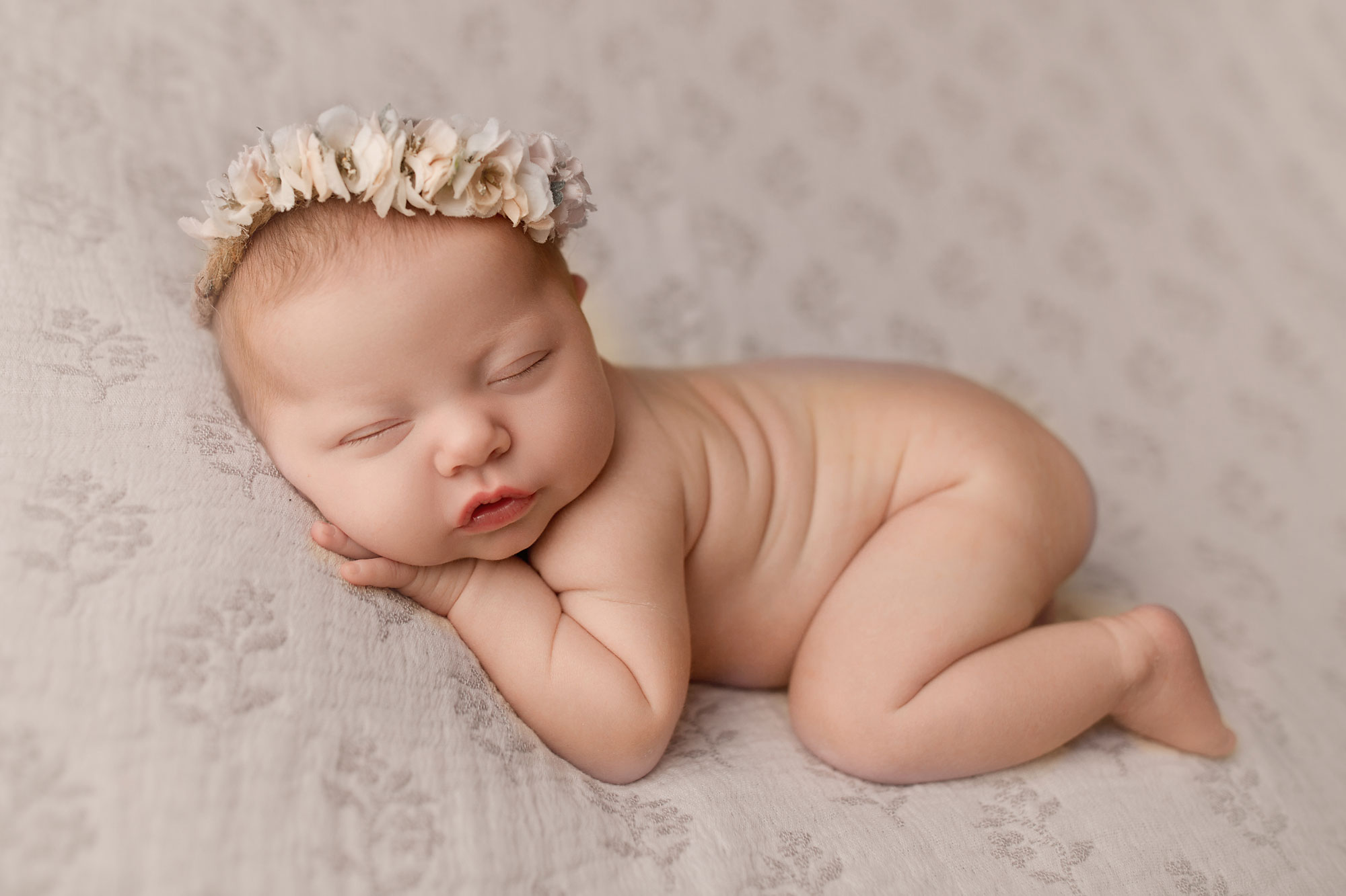 baby sleeping on a pink fabric