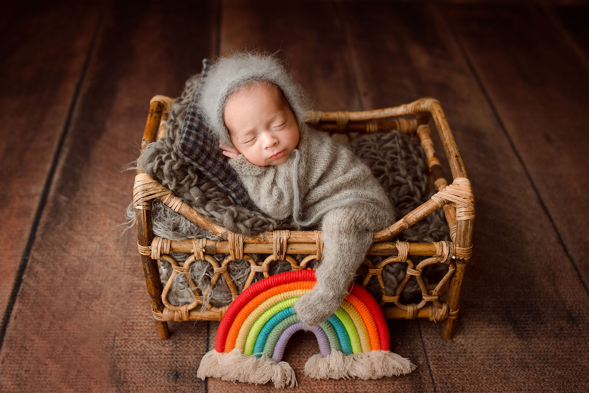 rainbow baby boy sleeping in a wooden bed