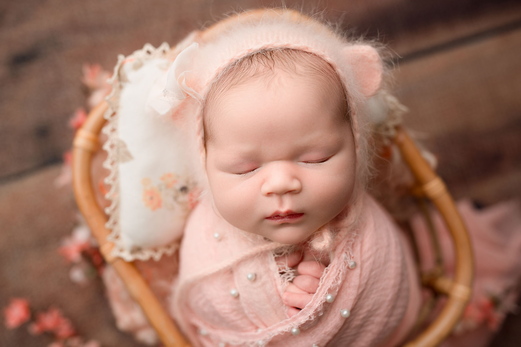 baby girl wearing a pink bear bonnet