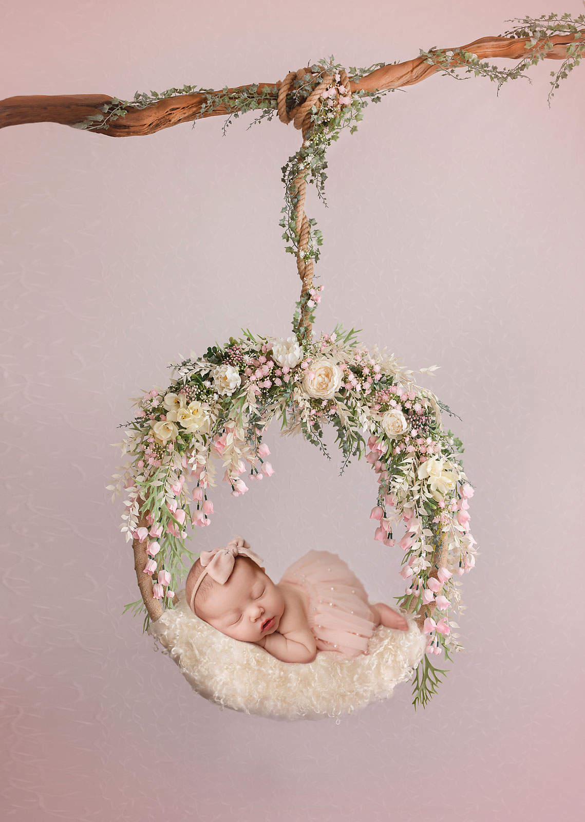 newborn photographer in NJ baby hanging on the wreath