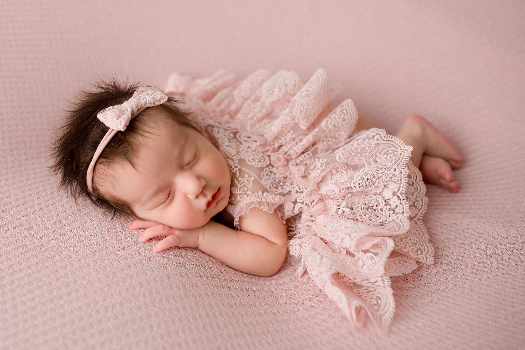 NJ newborn photographer capturing baby girl sleeping on a pink blanket